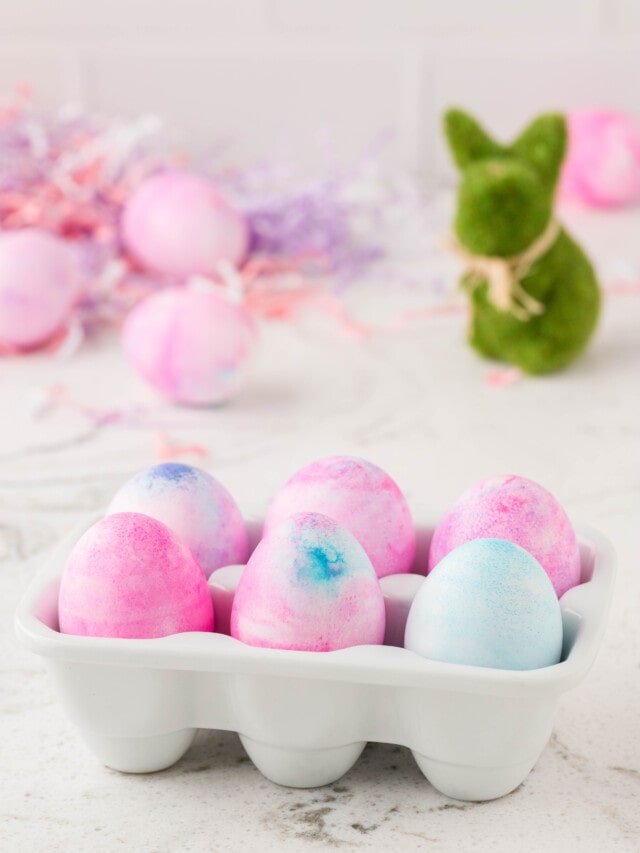 Easter Eggs Displayed in an Egg Carton with a Bunny in the Background