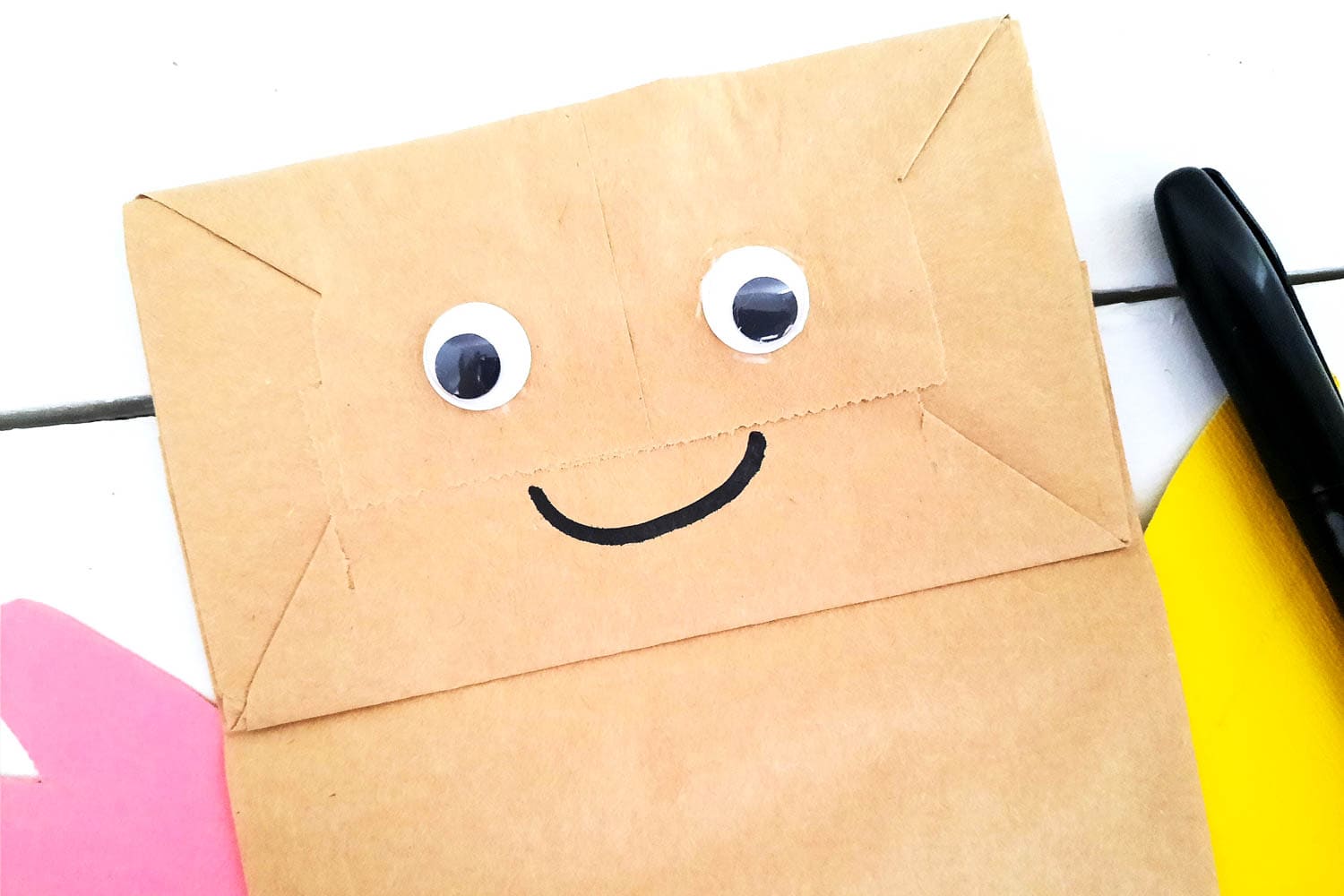 Add Googly Eyes and a Smiley Face to the Paper Bag