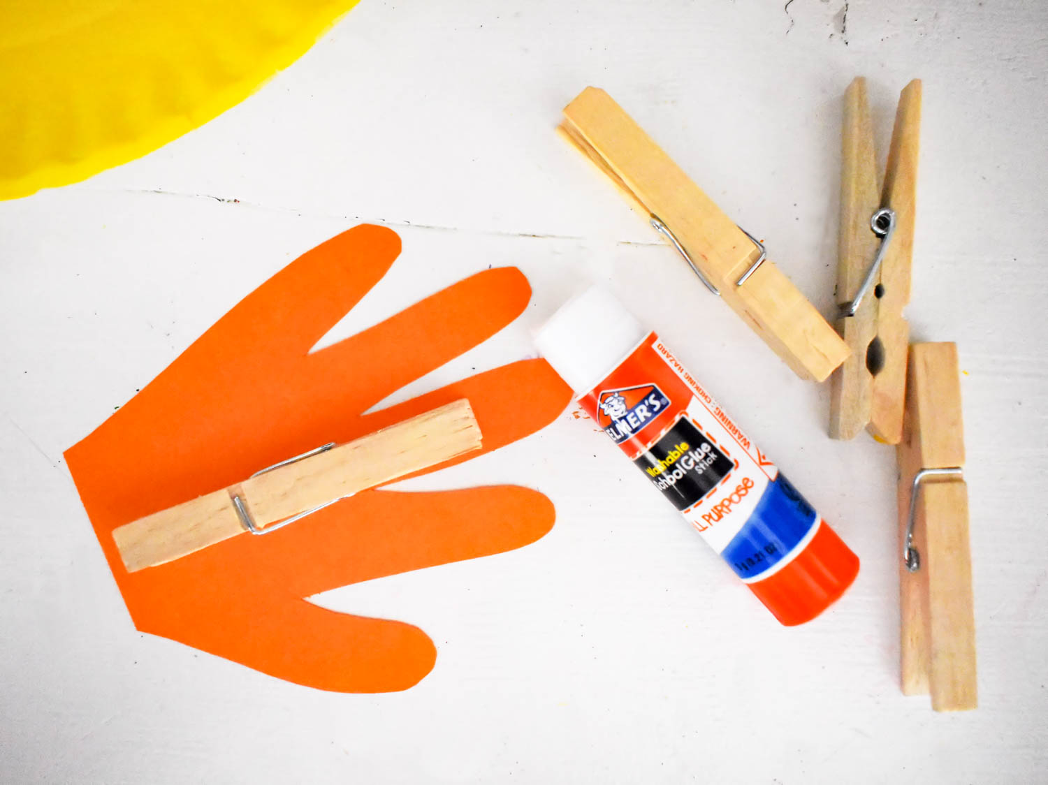 Glue the handprints to two of the painted clothespins