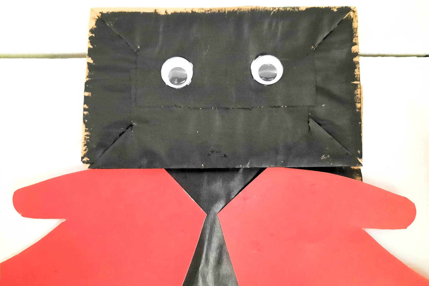 Glue on two Googly Eyes at the top of the black paper bag