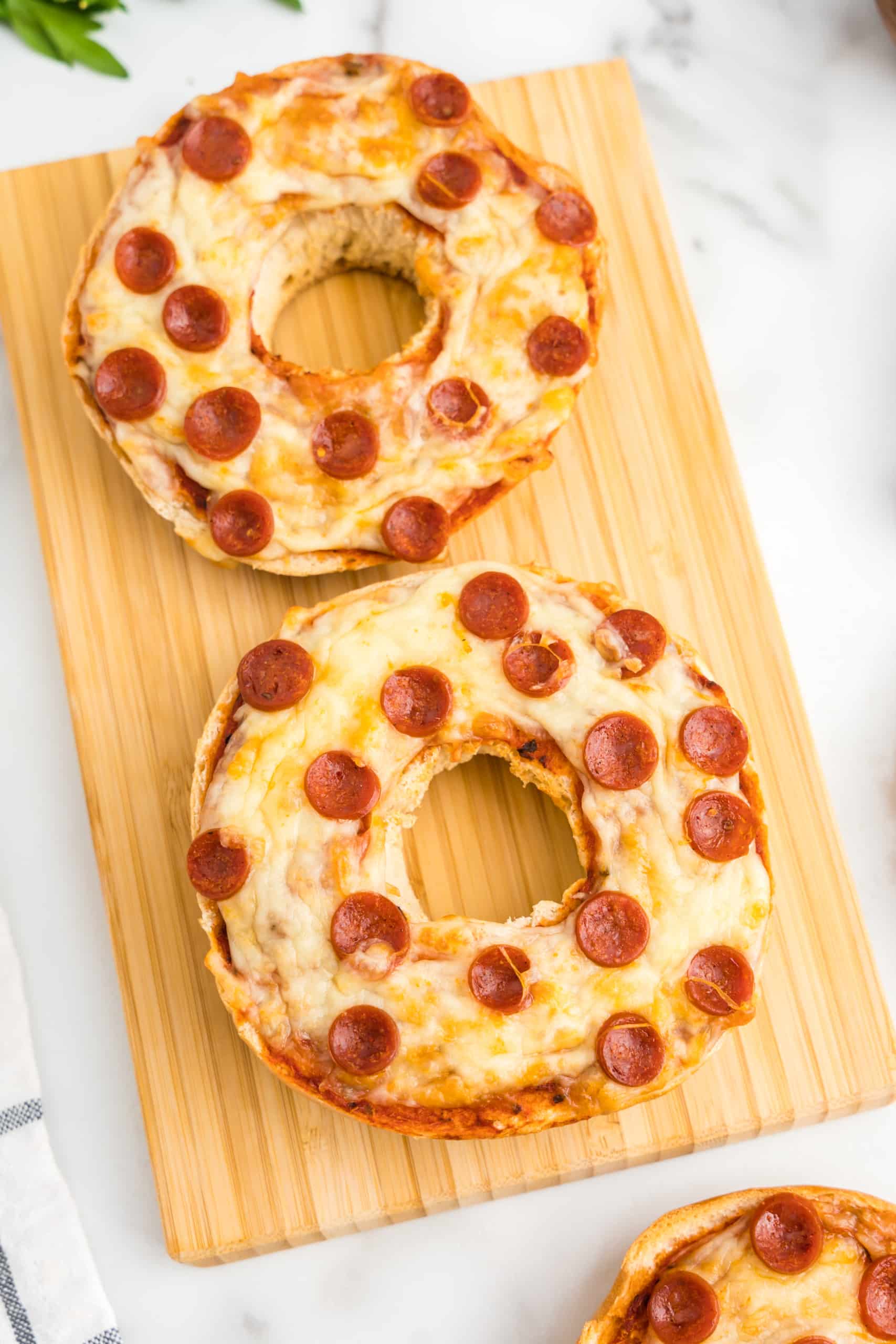 Cooked Air Fryer Pizza Bagels Displayed on a Wooden block.