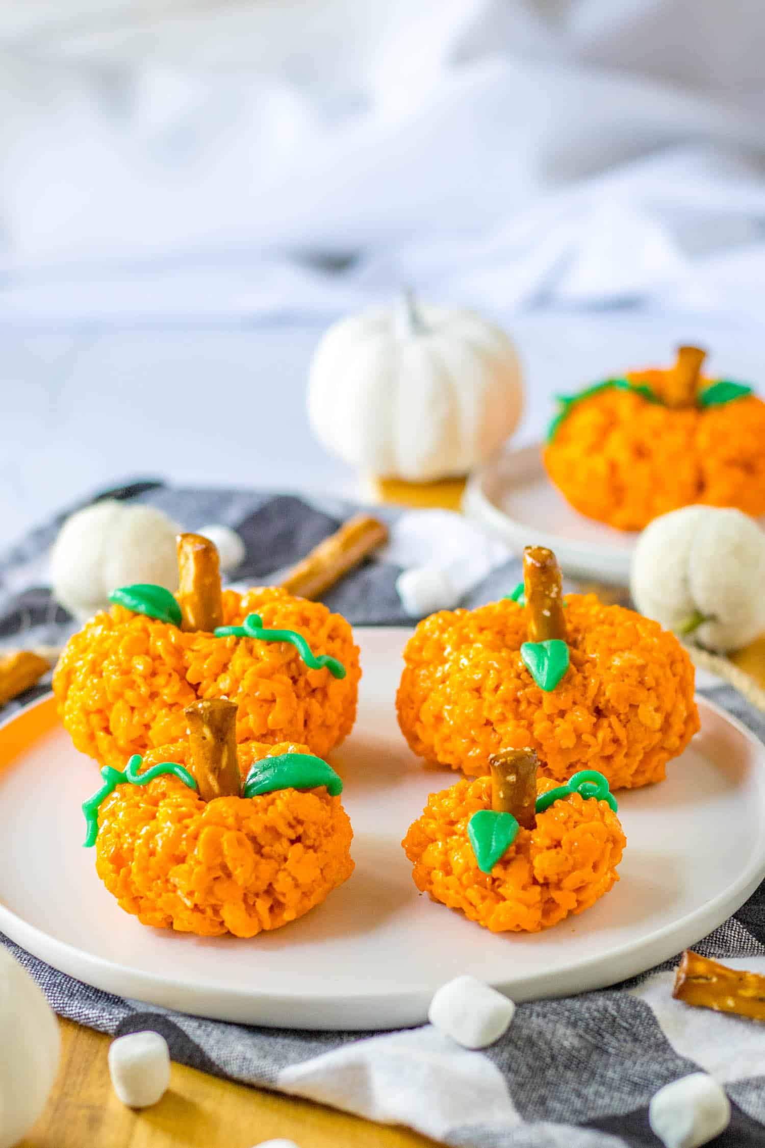 four pumpkins displayed on a white plate.