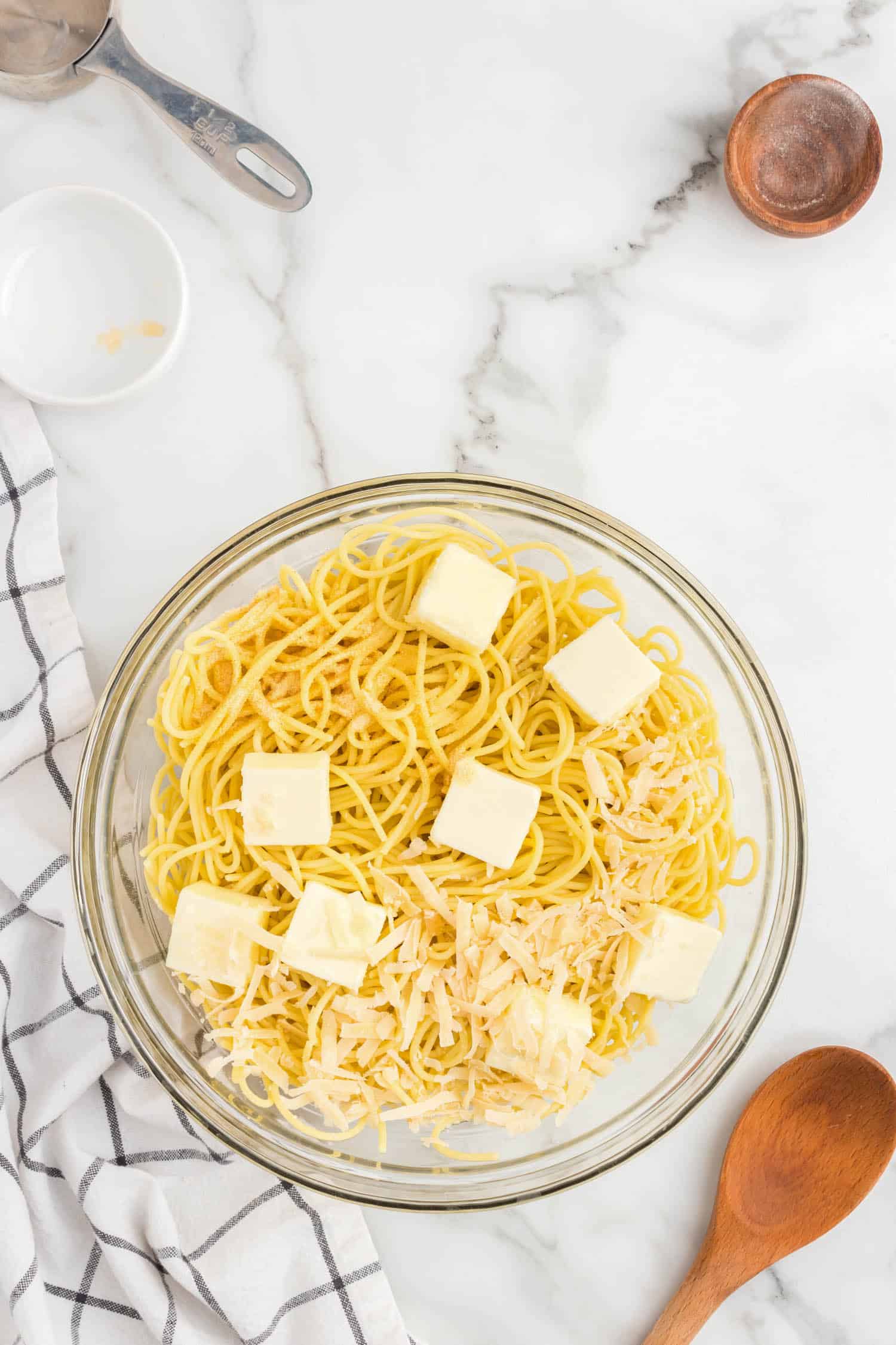 Add in the butter, parmesan cheese and garlic powder to the noodles.