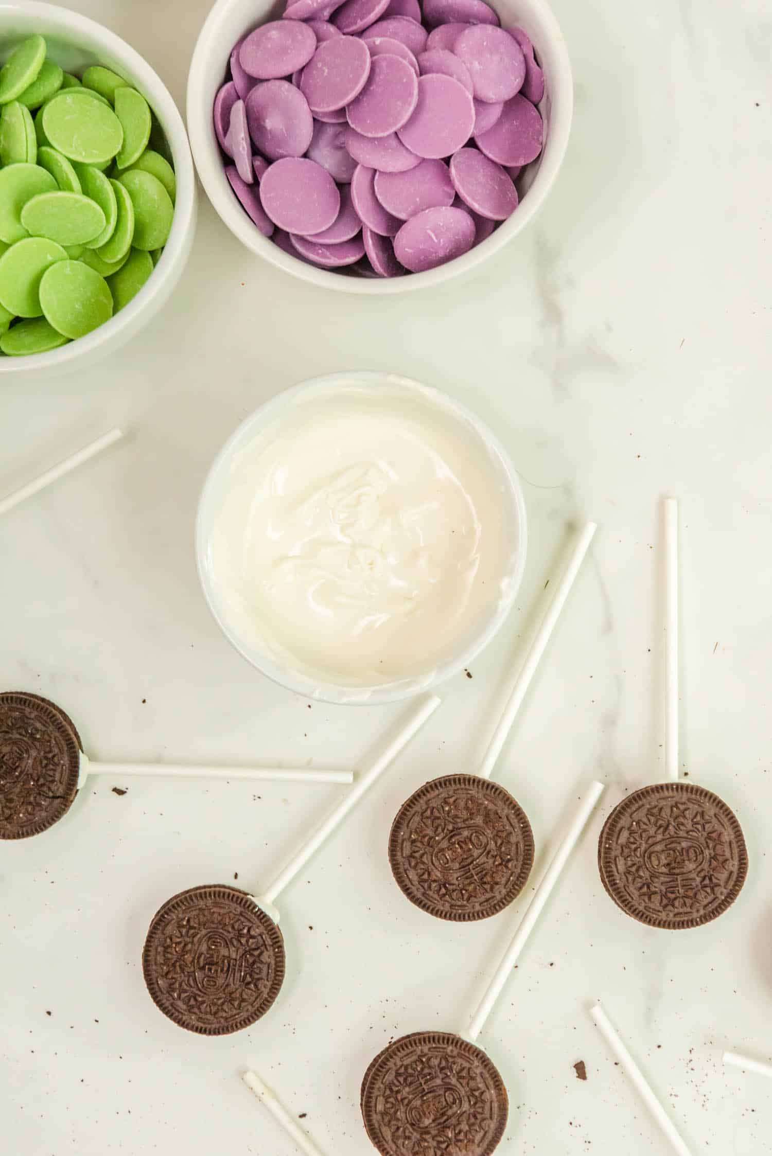 Dip the Cake Pop Sticks into the Melted White Wafers and Stick them into the Oreo Holes.
