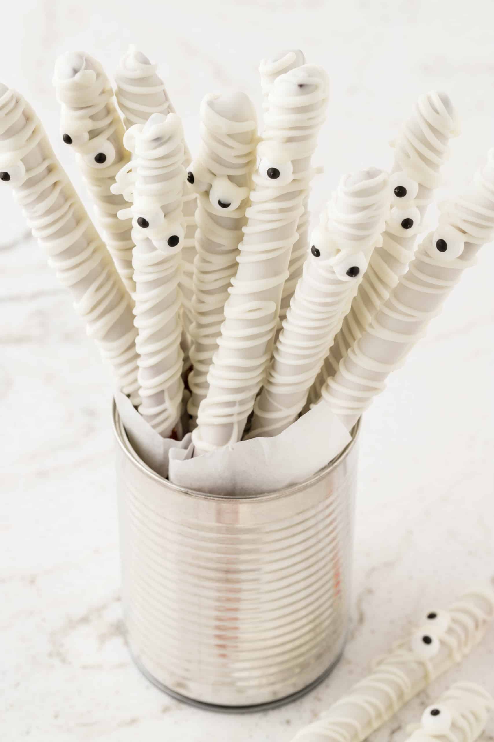 Mummy Pretzel Rods displayed in a tin can standing up.