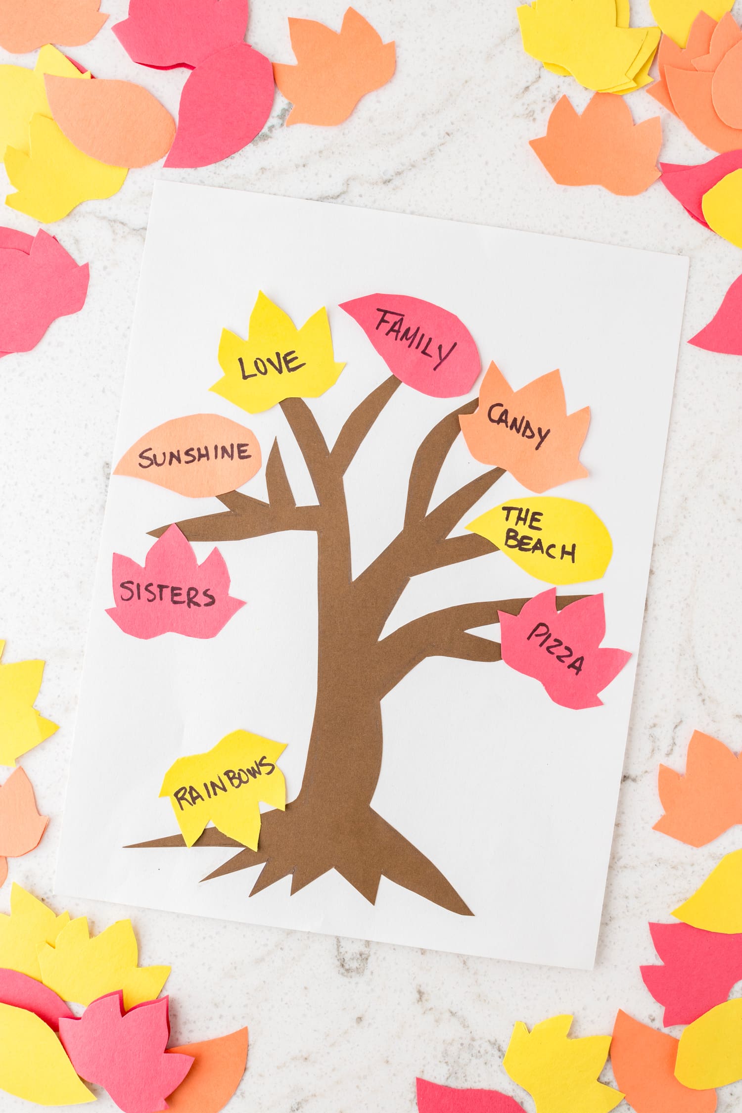 Completed Thankful Tree craft with leaves laying all around it.