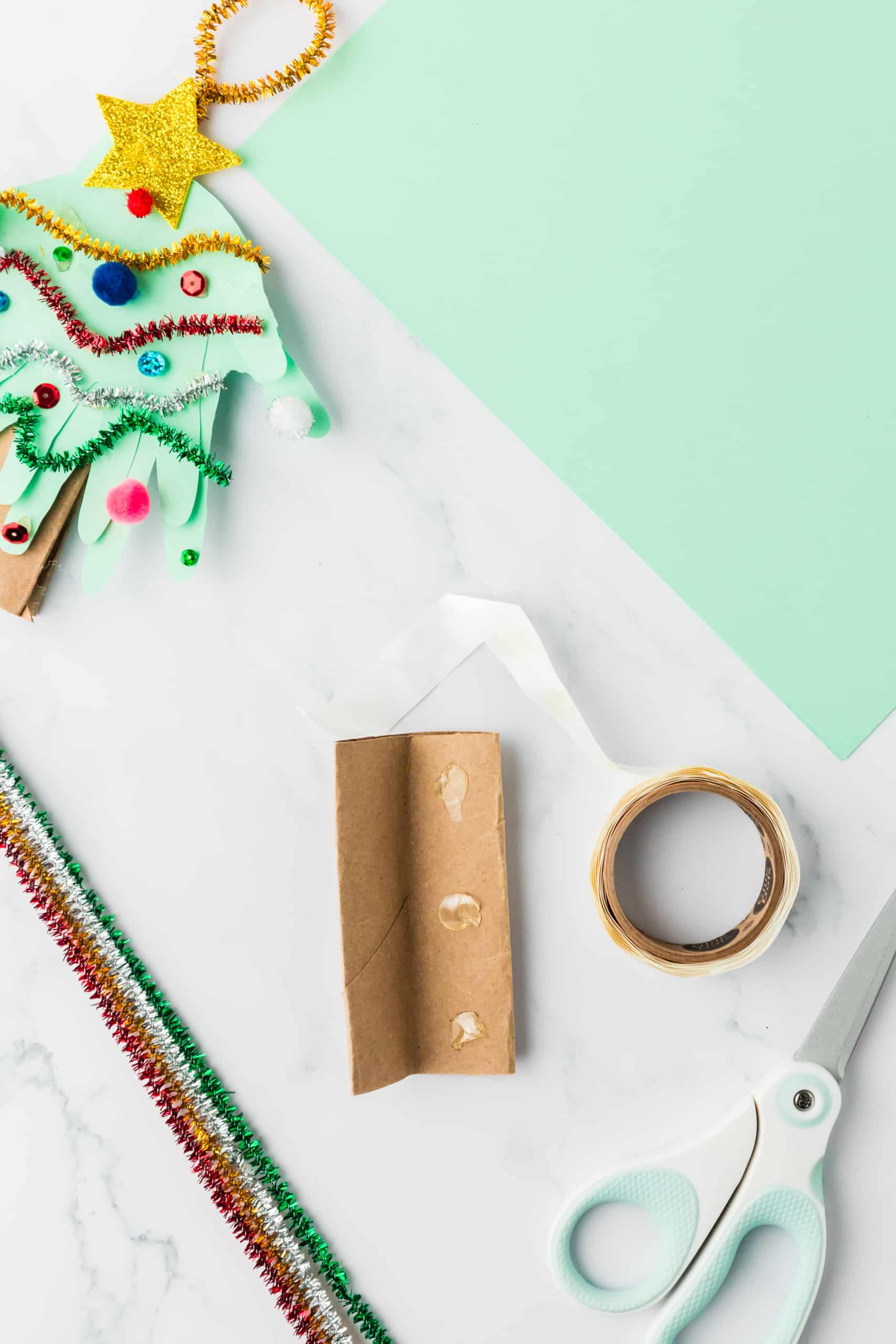 Fold the toilet paper roll in half and secure it with glue dots.