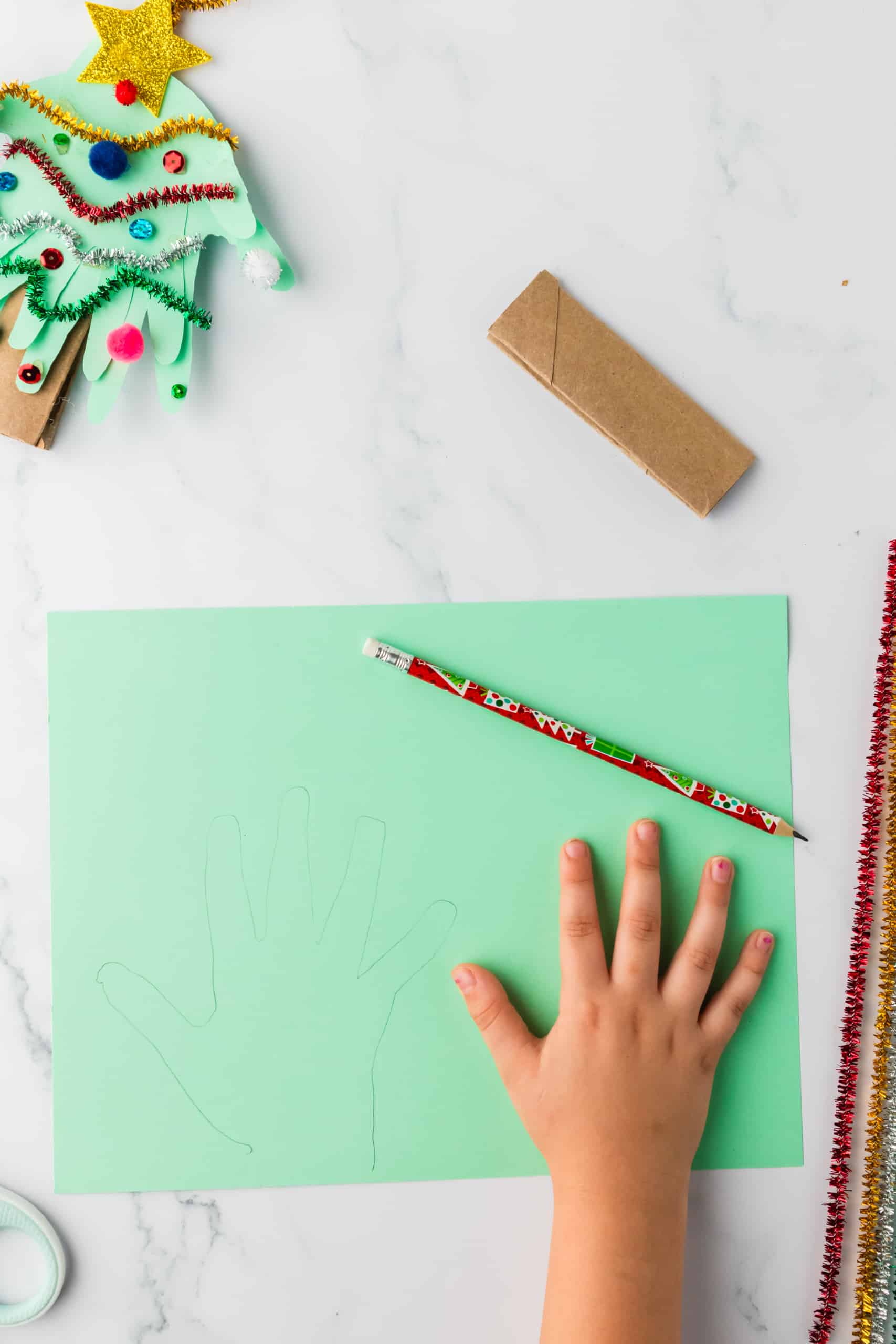 Trace your child's handprint three times on a piece of green paper and cut them out.