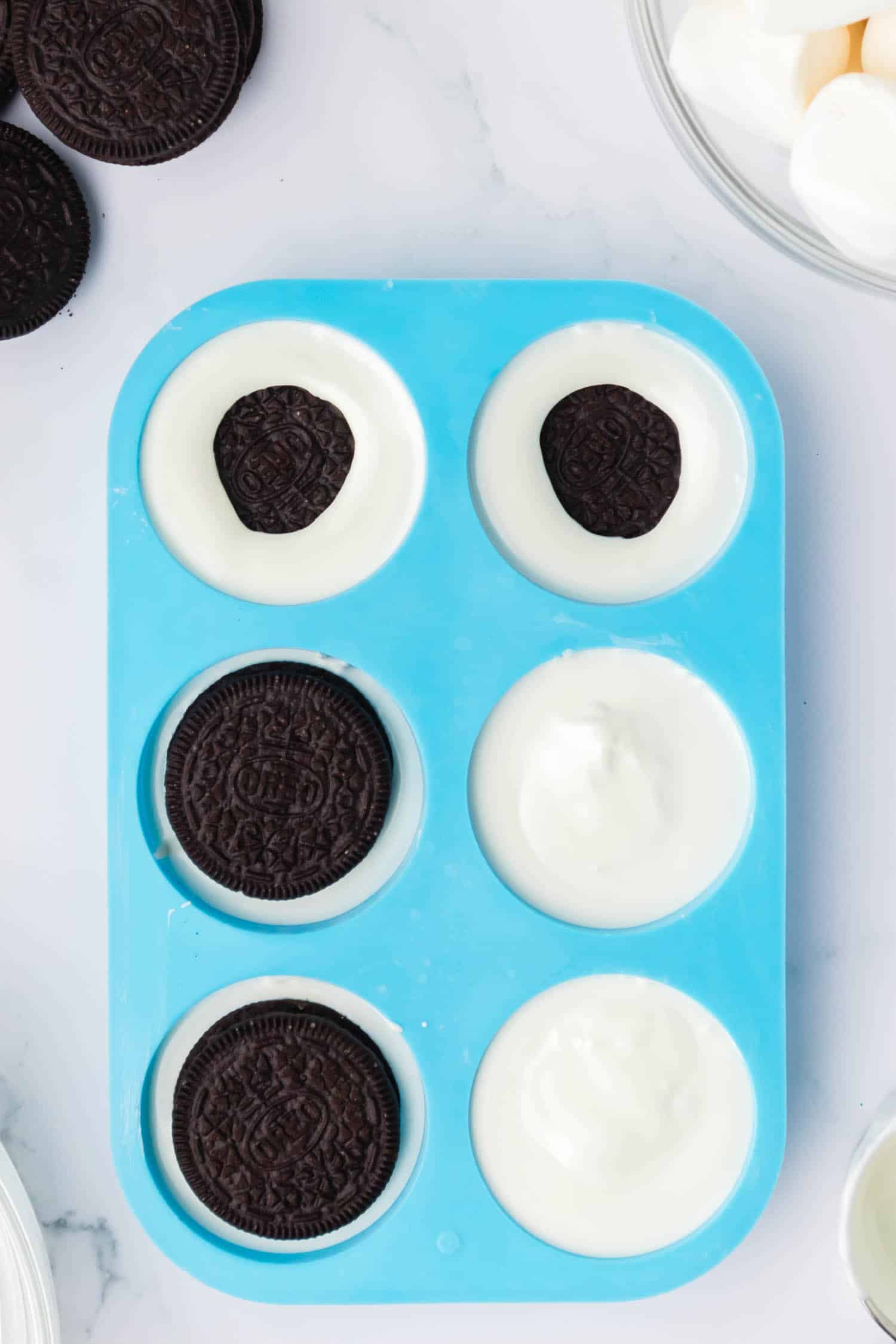 Set the cookie mold on a flat surface and fill 1/4 full with melted chocolate. Push a Oreo into the melted chocolate and cover completely.