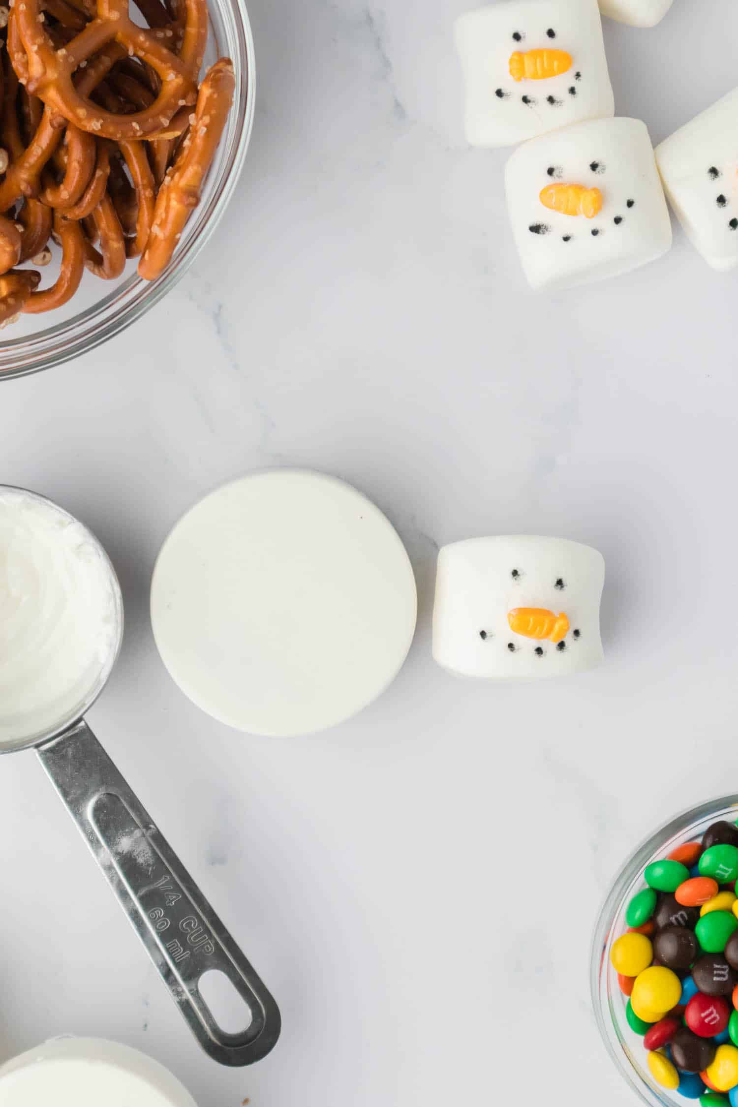 Using leftover Chocolate attach the Marshmallow to the Cookie for the Snowman Head.