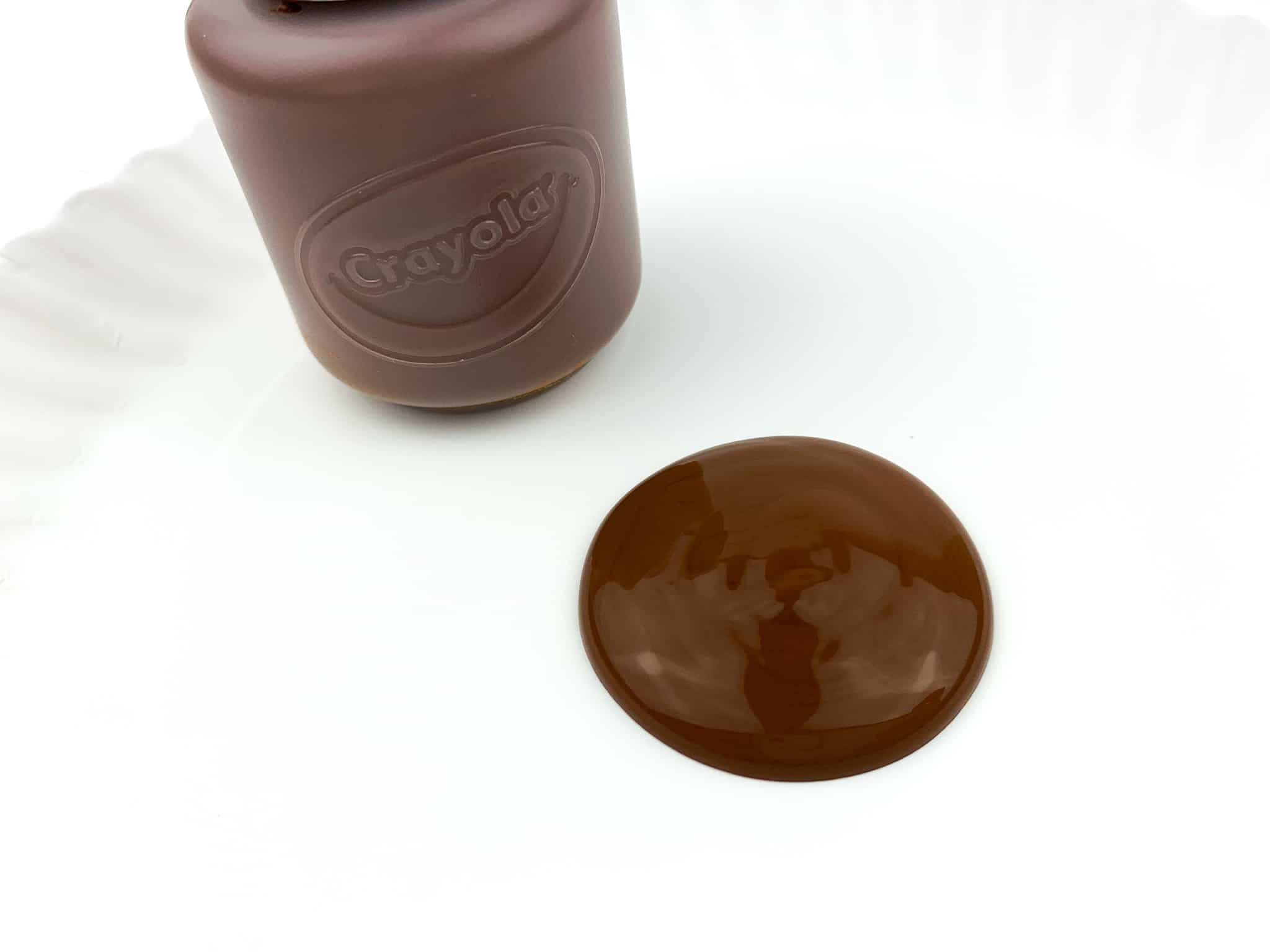 Pour some brown paint into the center of a paper plate.