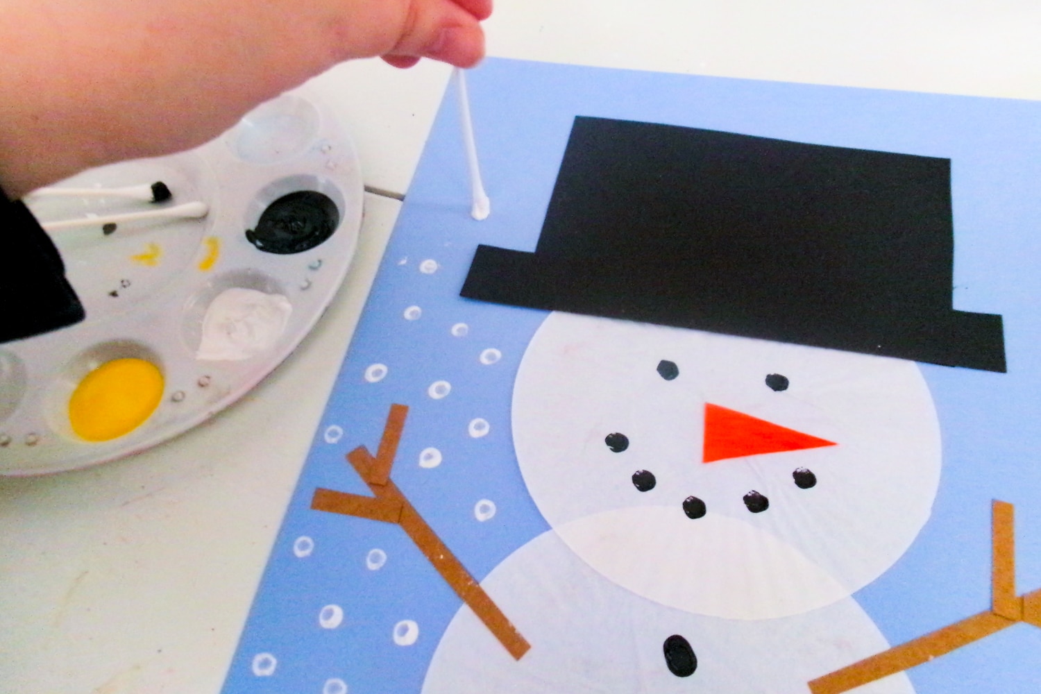 Decorating blue paper with white paint