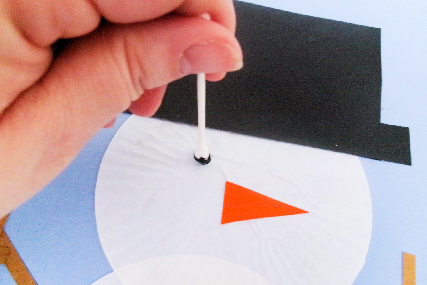 Paint eyes on snowman with Qtip