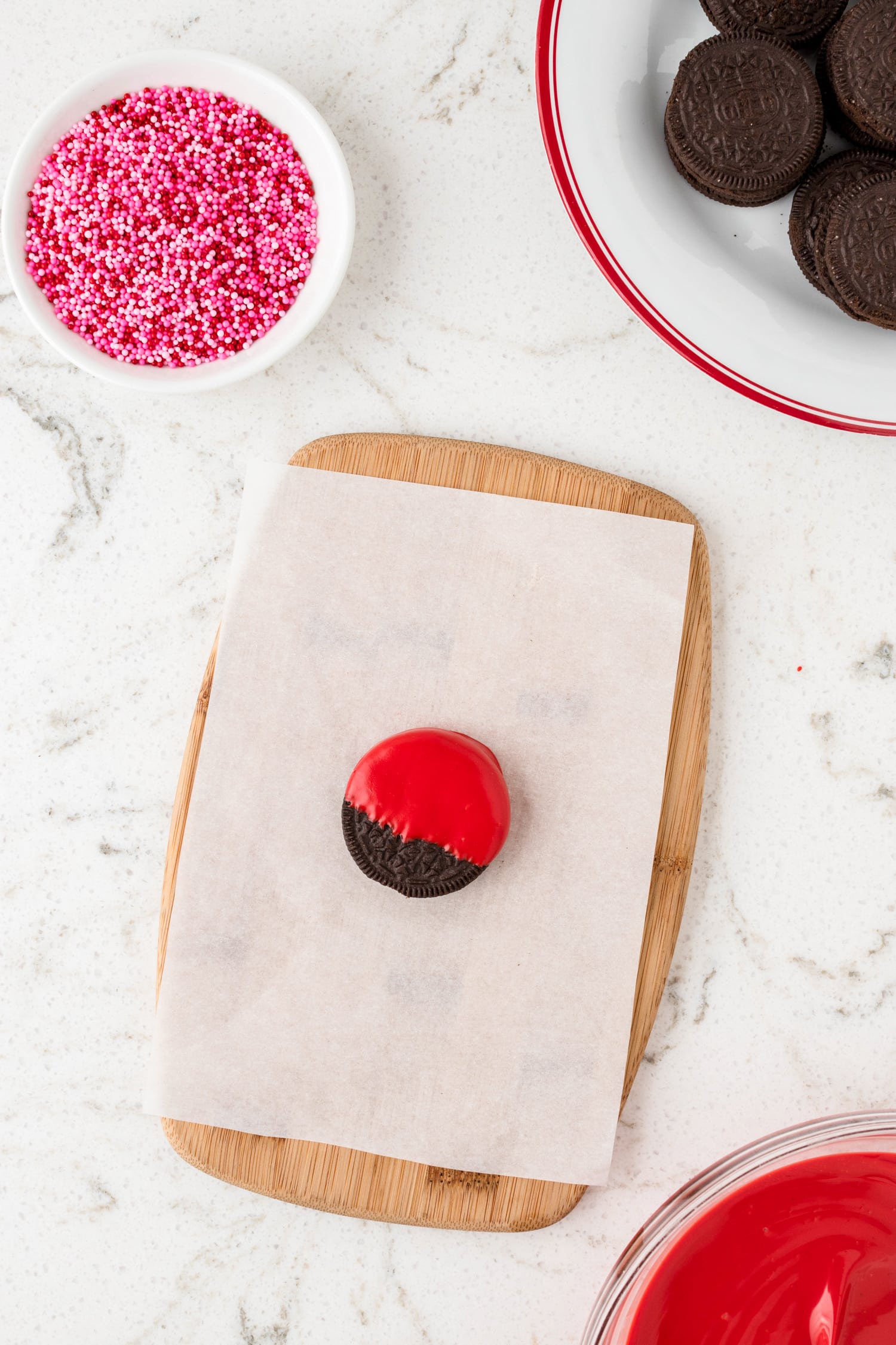 Dipped oreo cookie into melted red candy melt and laying on parchment paper