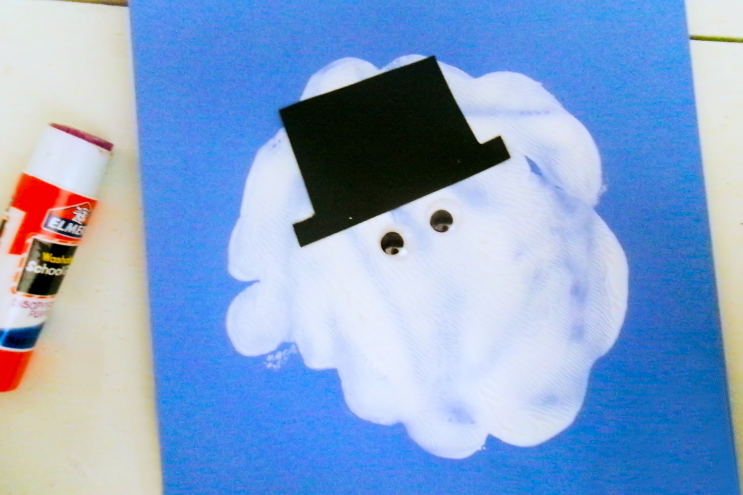 White paint splat with snowman hat and eyes