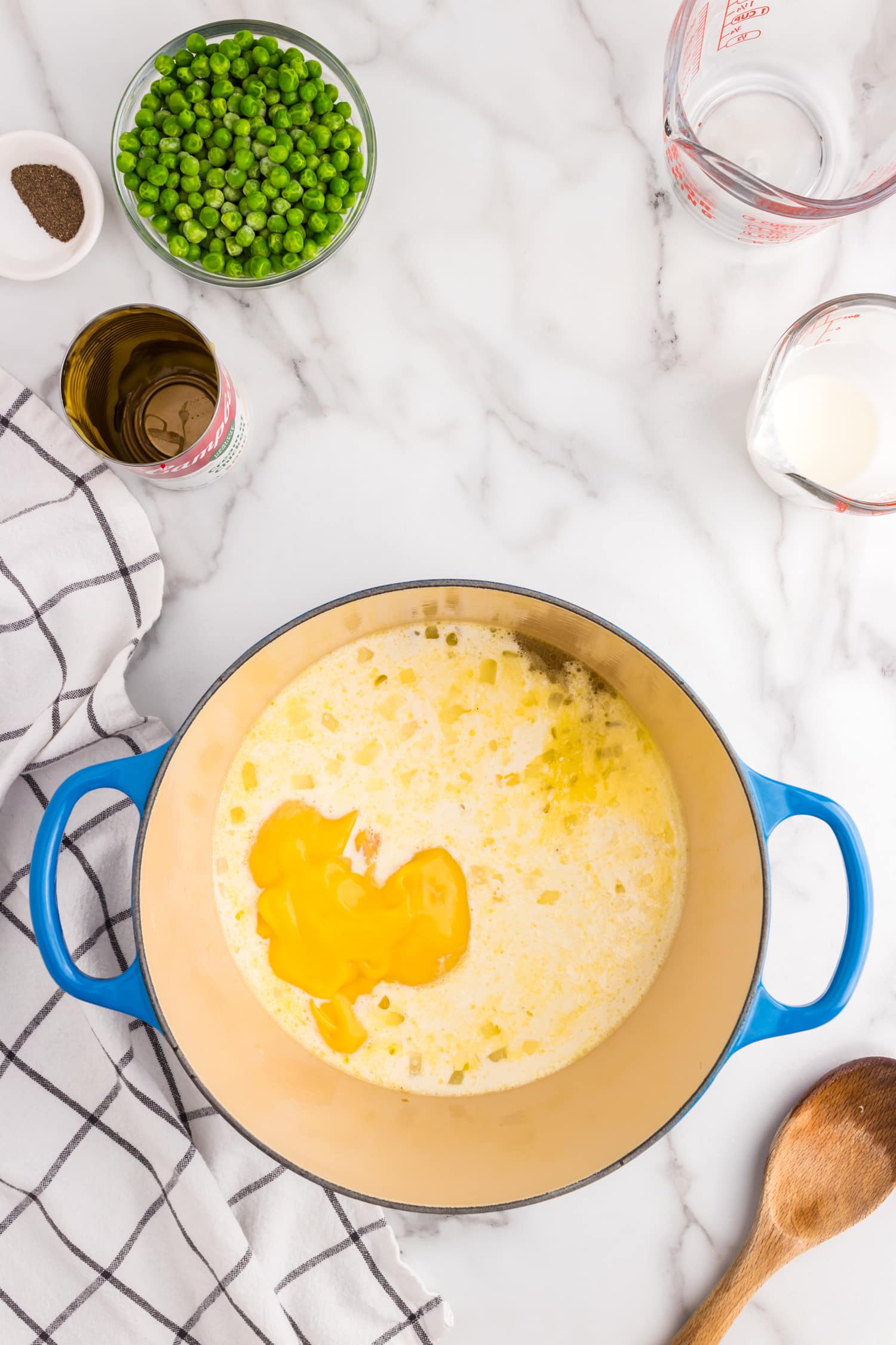 Adding heavy whipping cream and cream of chicken soup for Chicken and Noodles recipe in stock pot