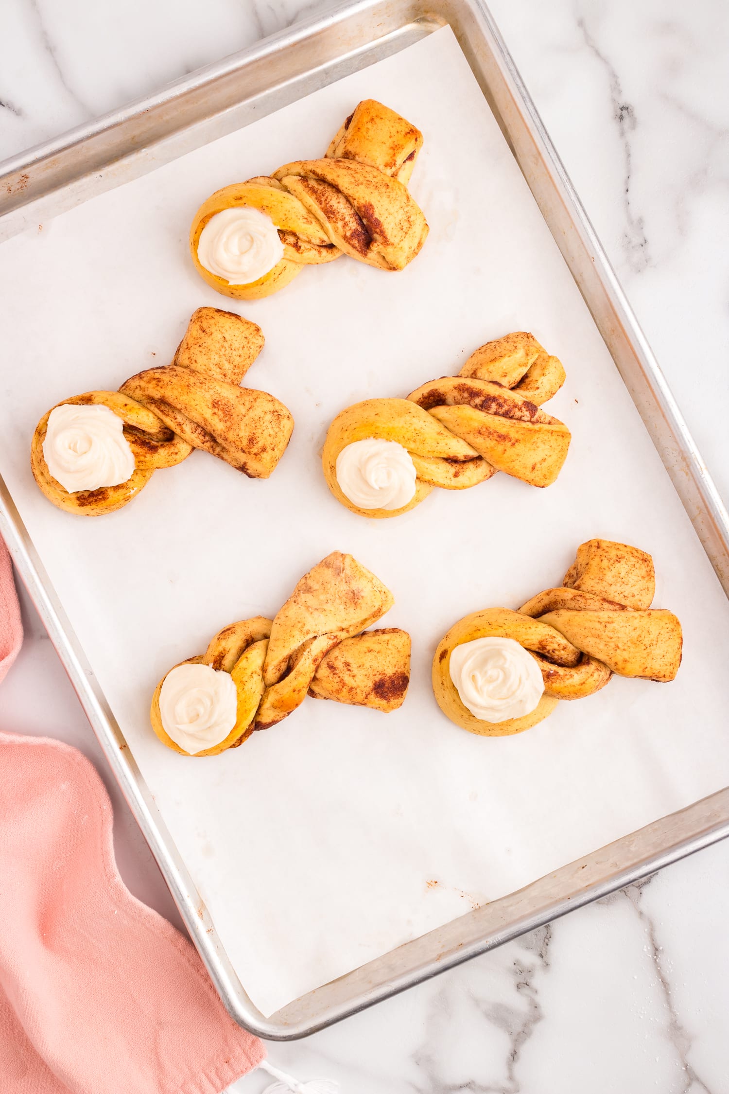 Once they're cooled place a spoon full of the frosting onto the bottom of the twist to make a bunny tail.