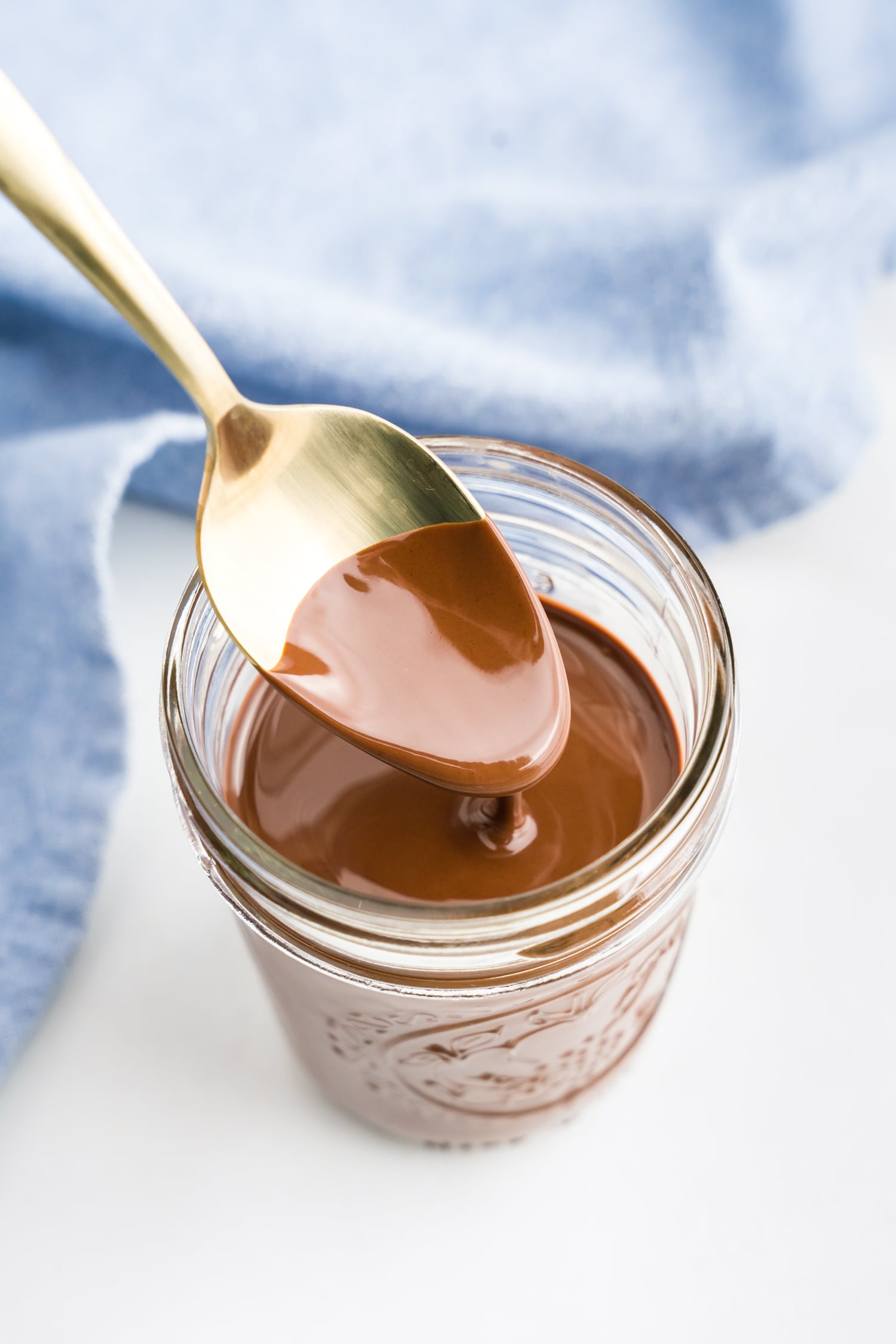 Homemade Magic Shell melted in jar with spoon