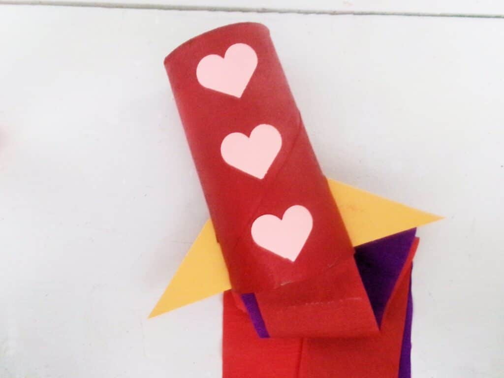 Glue them to the outside of the toilet paper roll.