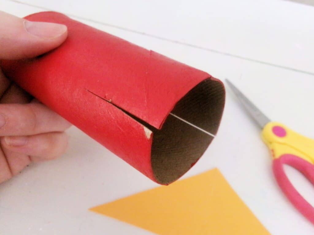 When the paint is completely dry, cut two slits into one end of the toilet paper roll.