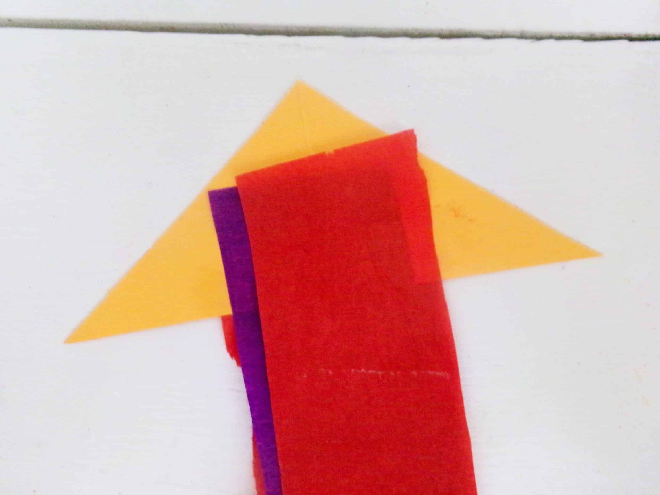 Glue one end of the streamers into the center of the yellow triangle.