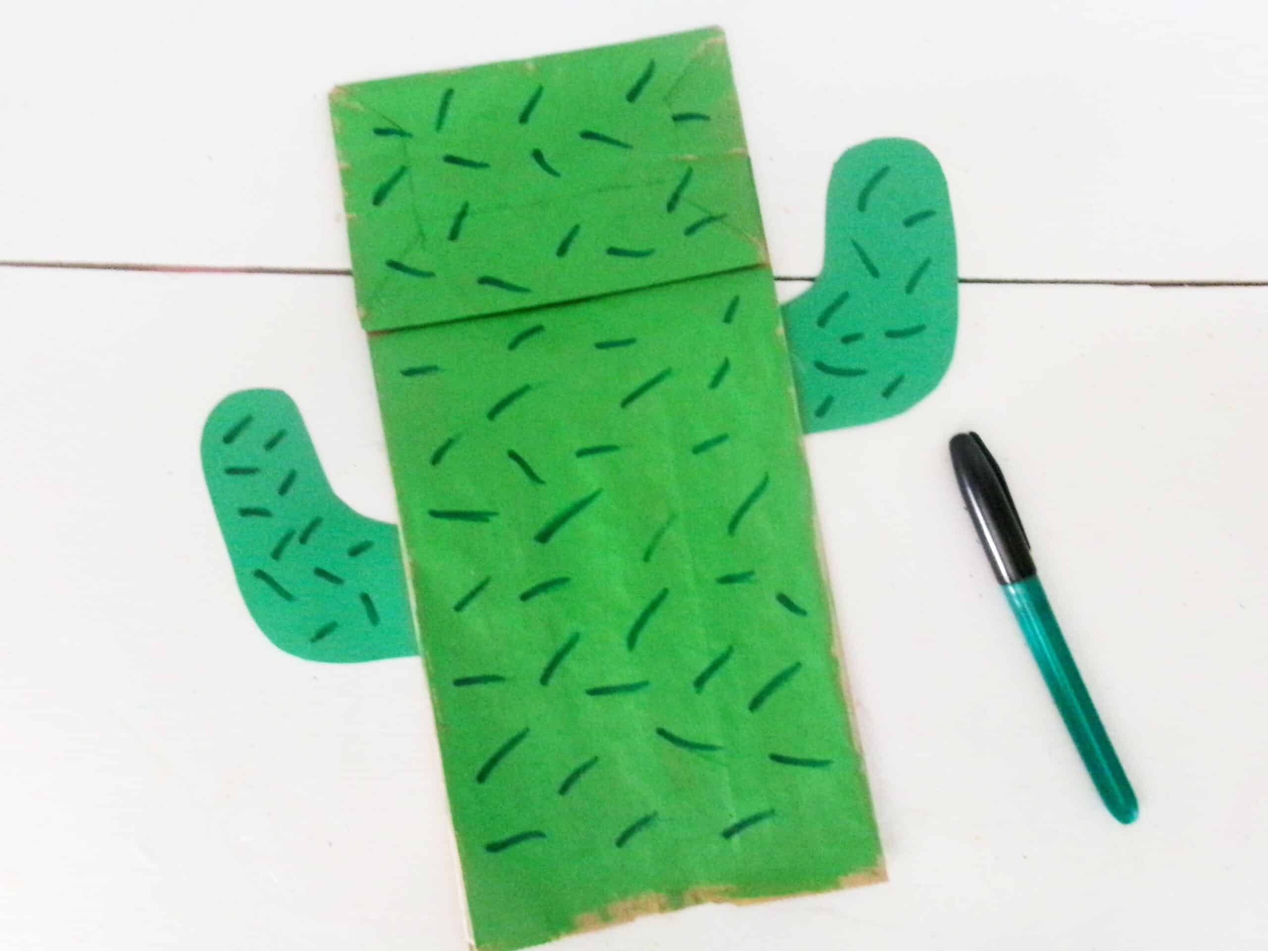 Using a green marker, randomly add dashes all around the cactus to make thorns.