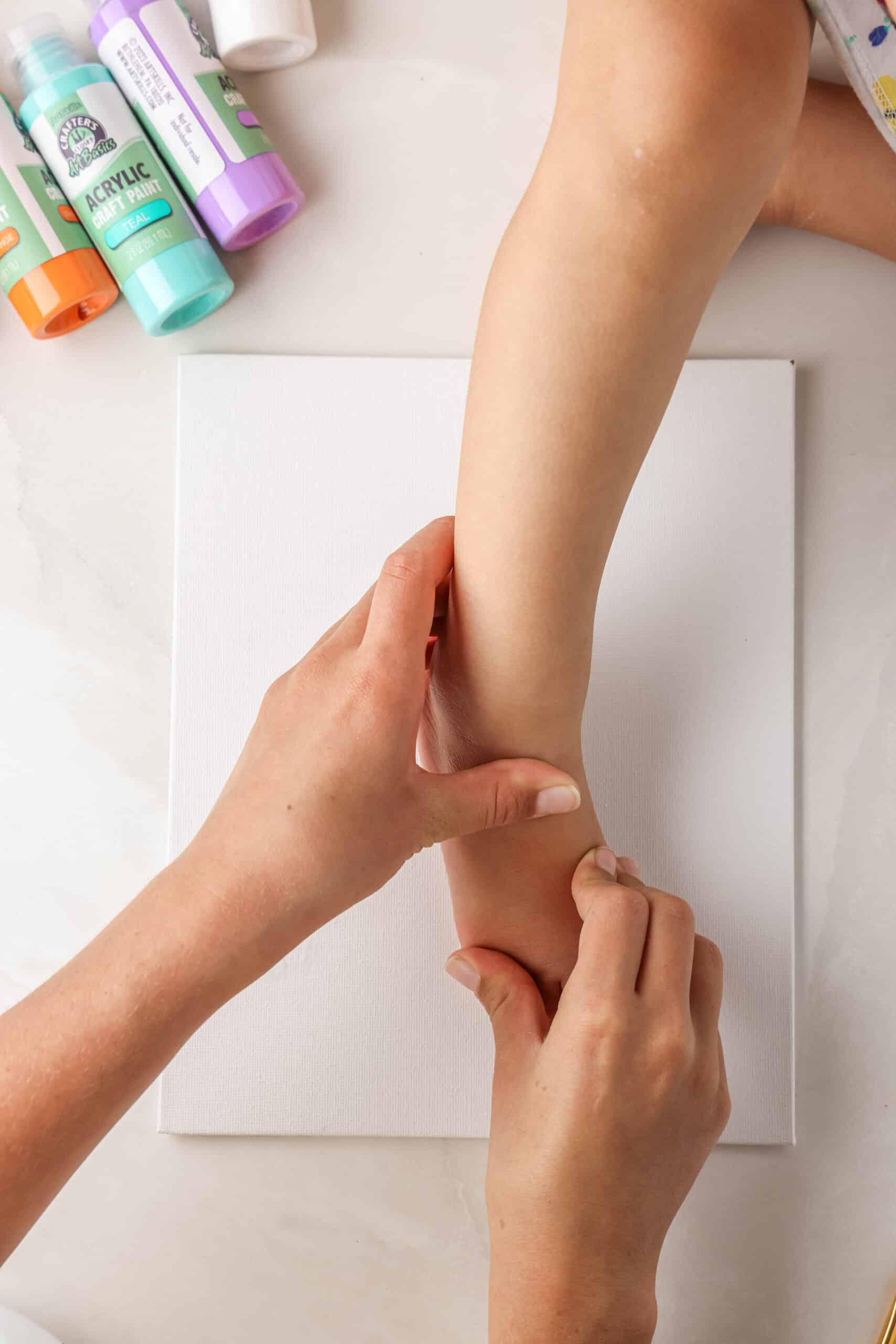 Putting glue on the right foot and placing it on the canvas to make the left wing of the butterfly.