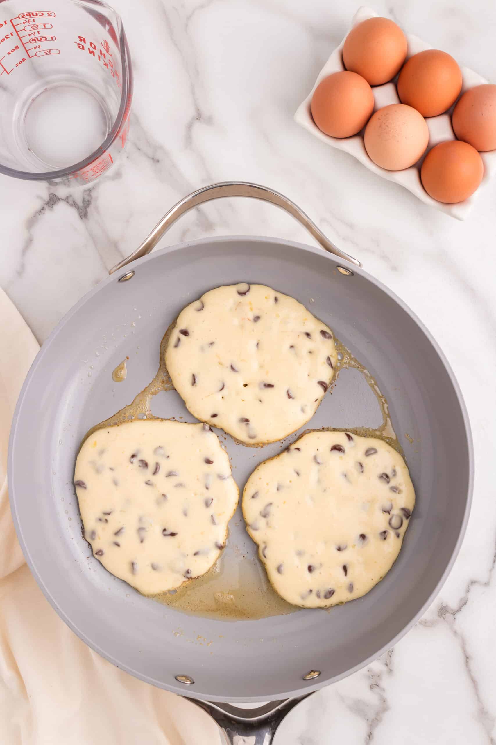 Heat a pan and pour pancake batter in 3 separate sections