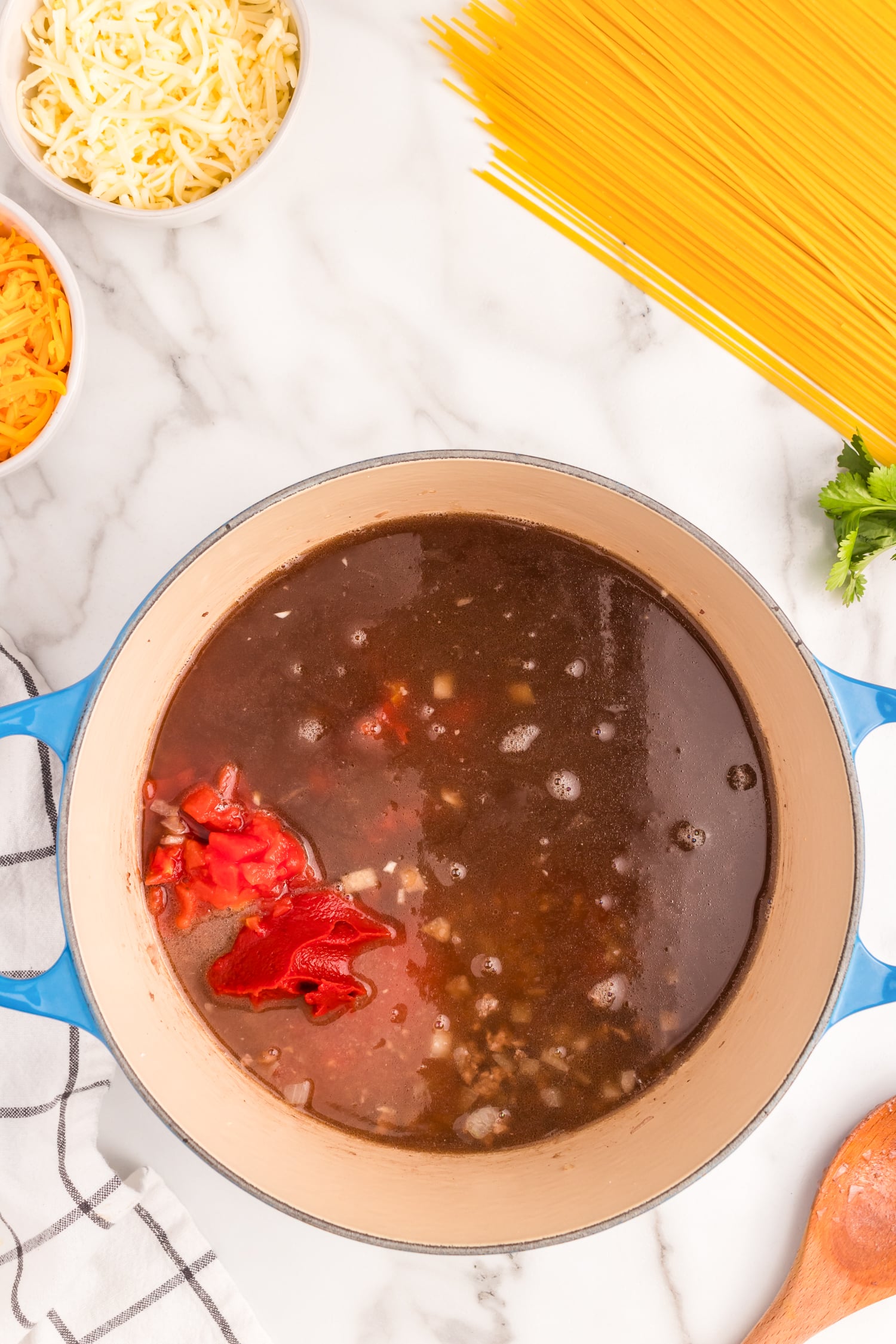 Add in Rotel tomatoes, tomato sauce, taco seasoning, beef broth, tomato paste, and Worcestershire sauce. Bring the mixture to a boil.
