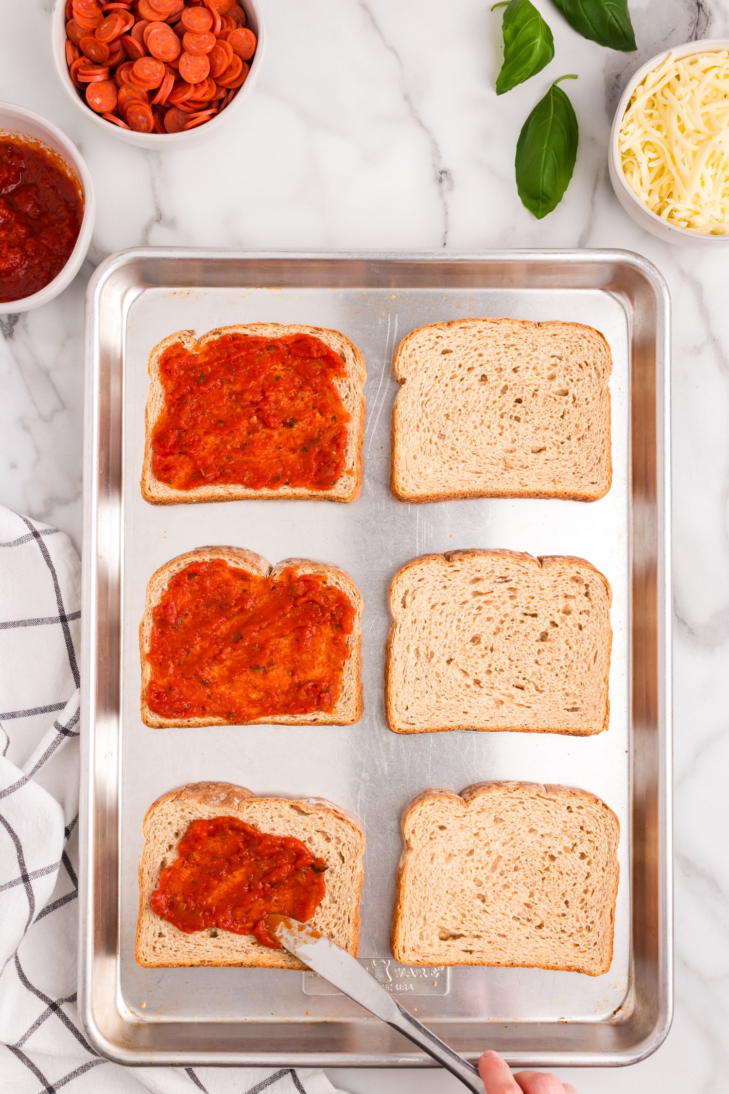 Remove from the oven and add your pizza sauce on each slice.