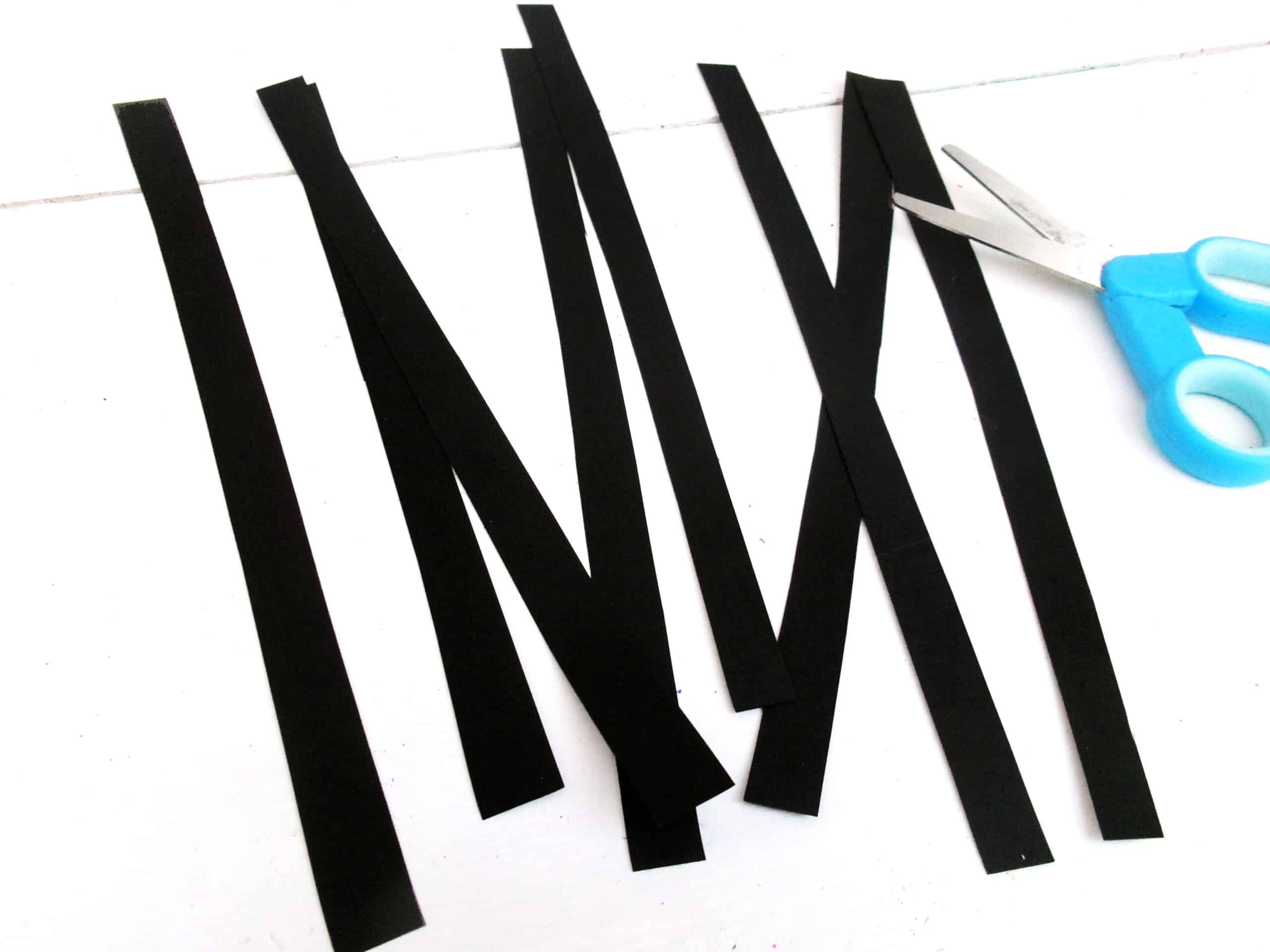 While the paint is drying, cut thin strips from black cardstock.