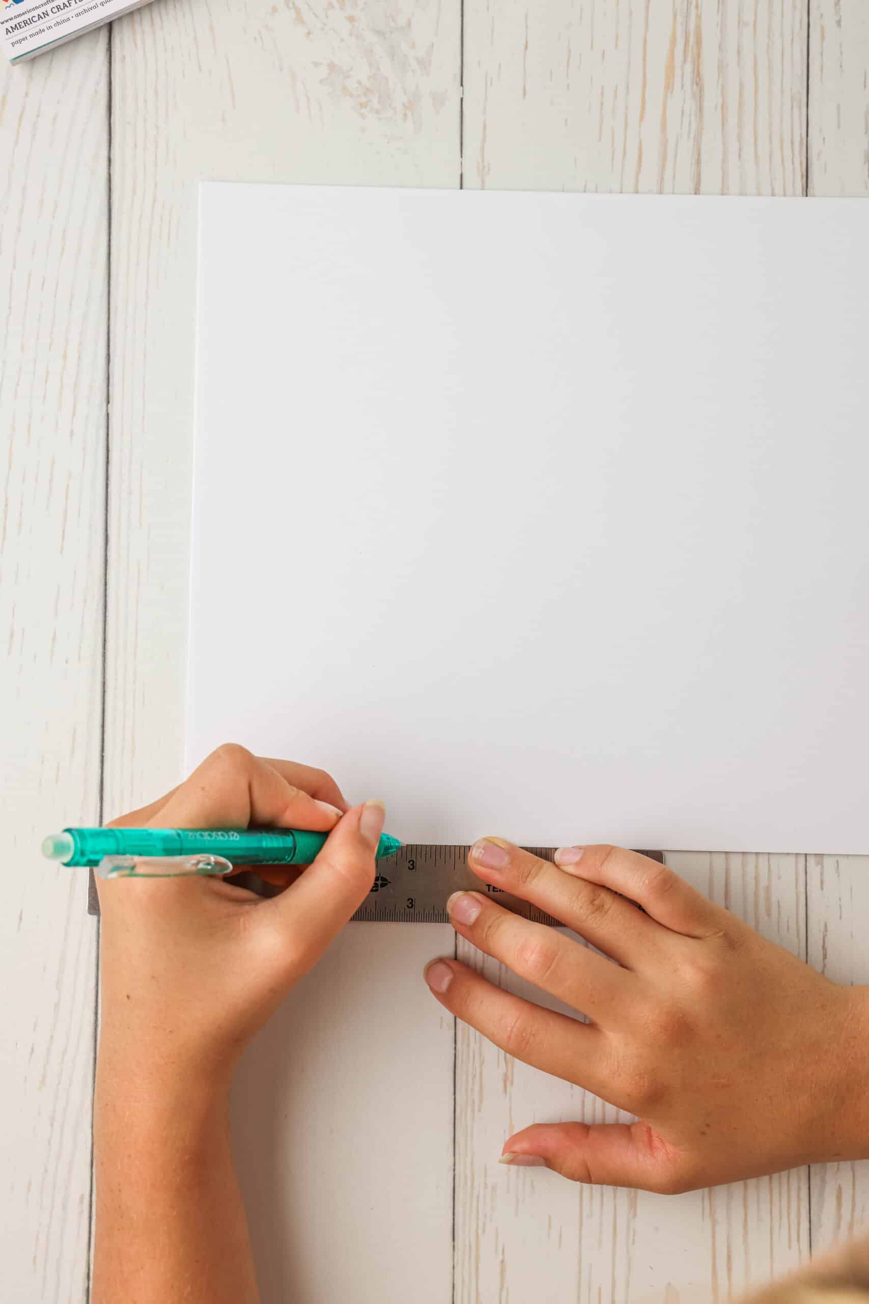 With your plain white paper turned horizontally, Measure 2 3/4 inches from the left side. Mark it with a pen and do that 2 more times so there are 3 marks on the paper.