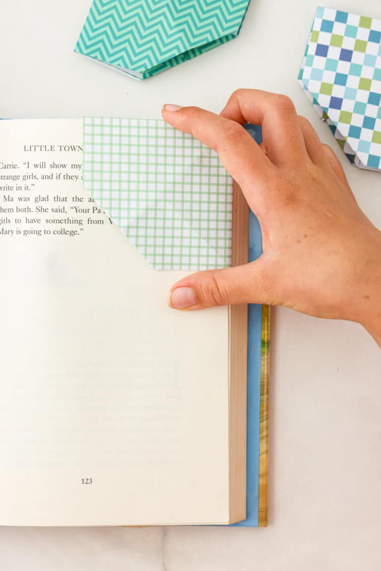 A Origami Corner Bookmark being placed on pages of a book.