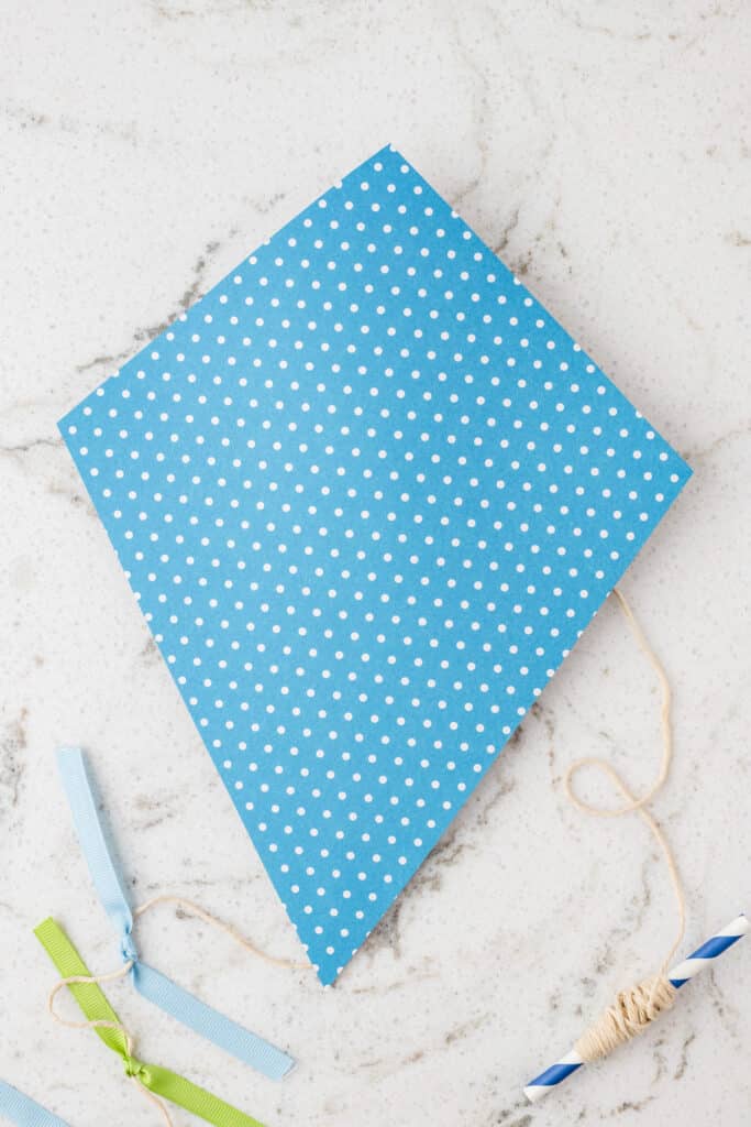 The completed Paper Kite Craft with the printed cardstock side showing with complimentary ribbon colors