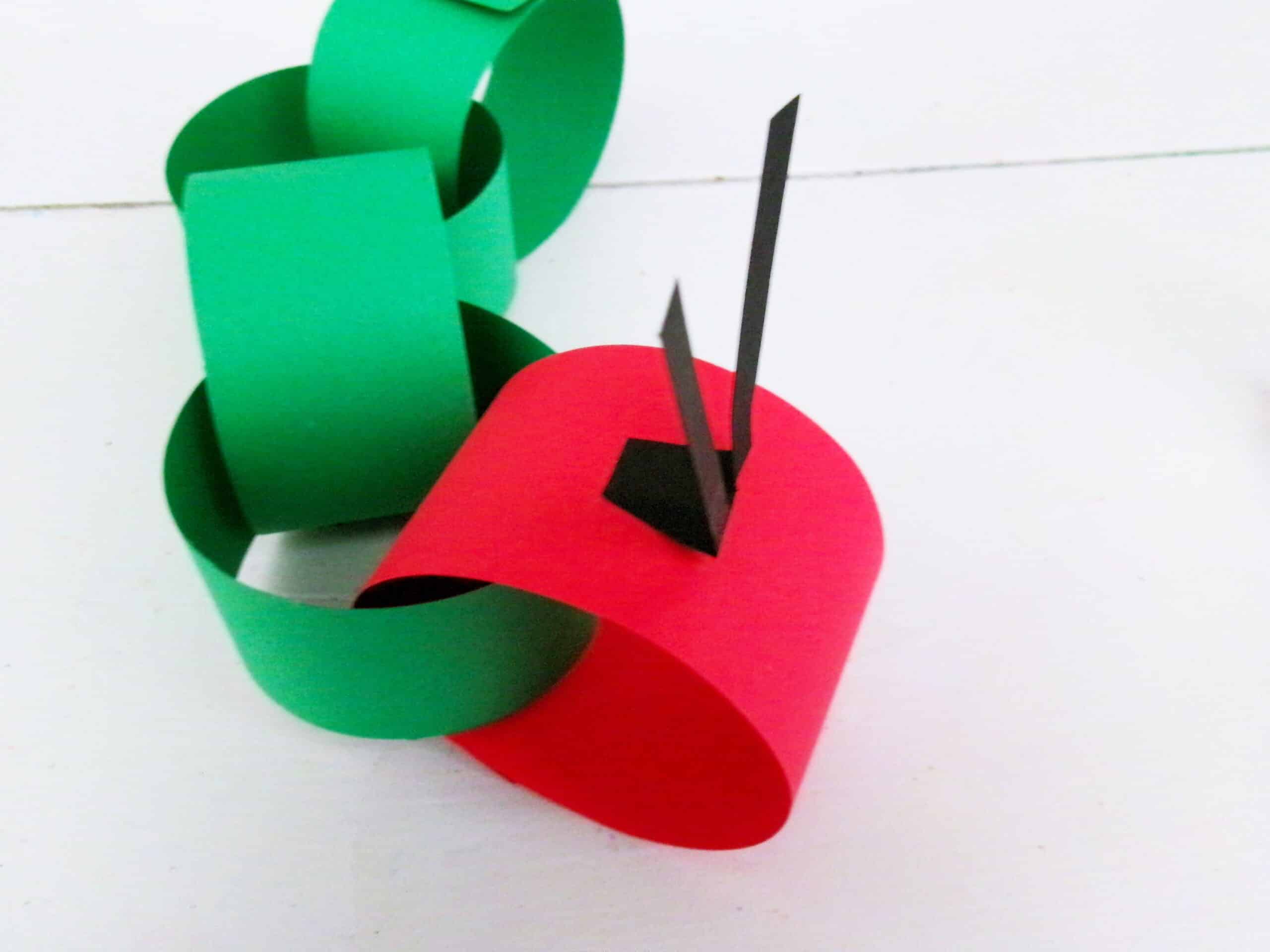 Bring the red strip through one end of the green loop and attach the antennas.