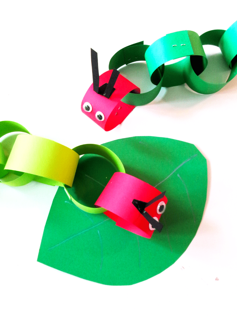 Overhead view of two completed caterpillars on green leaves.