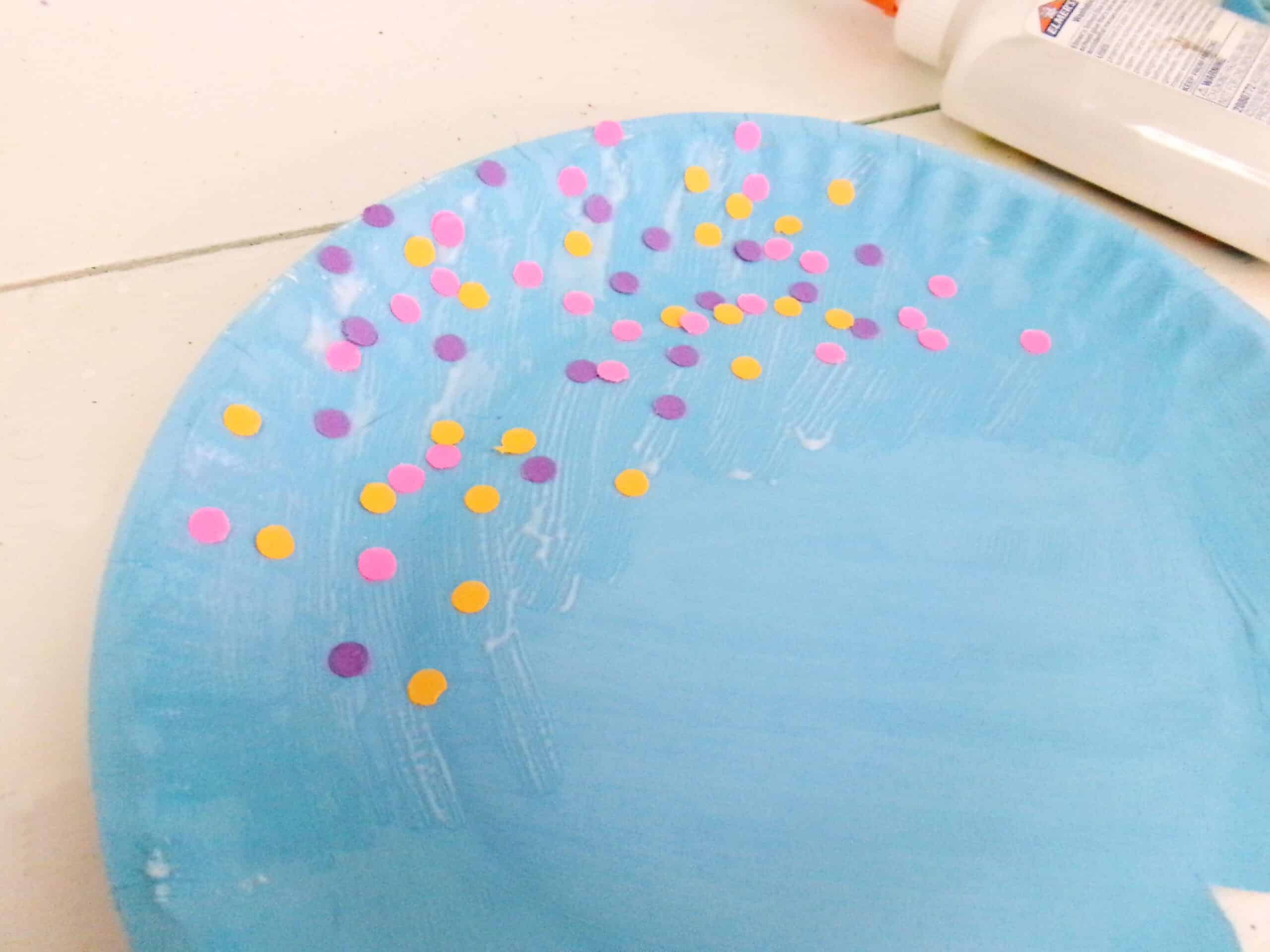 Put glue at the top of the plate and sprinkle on the little hole punch circles.