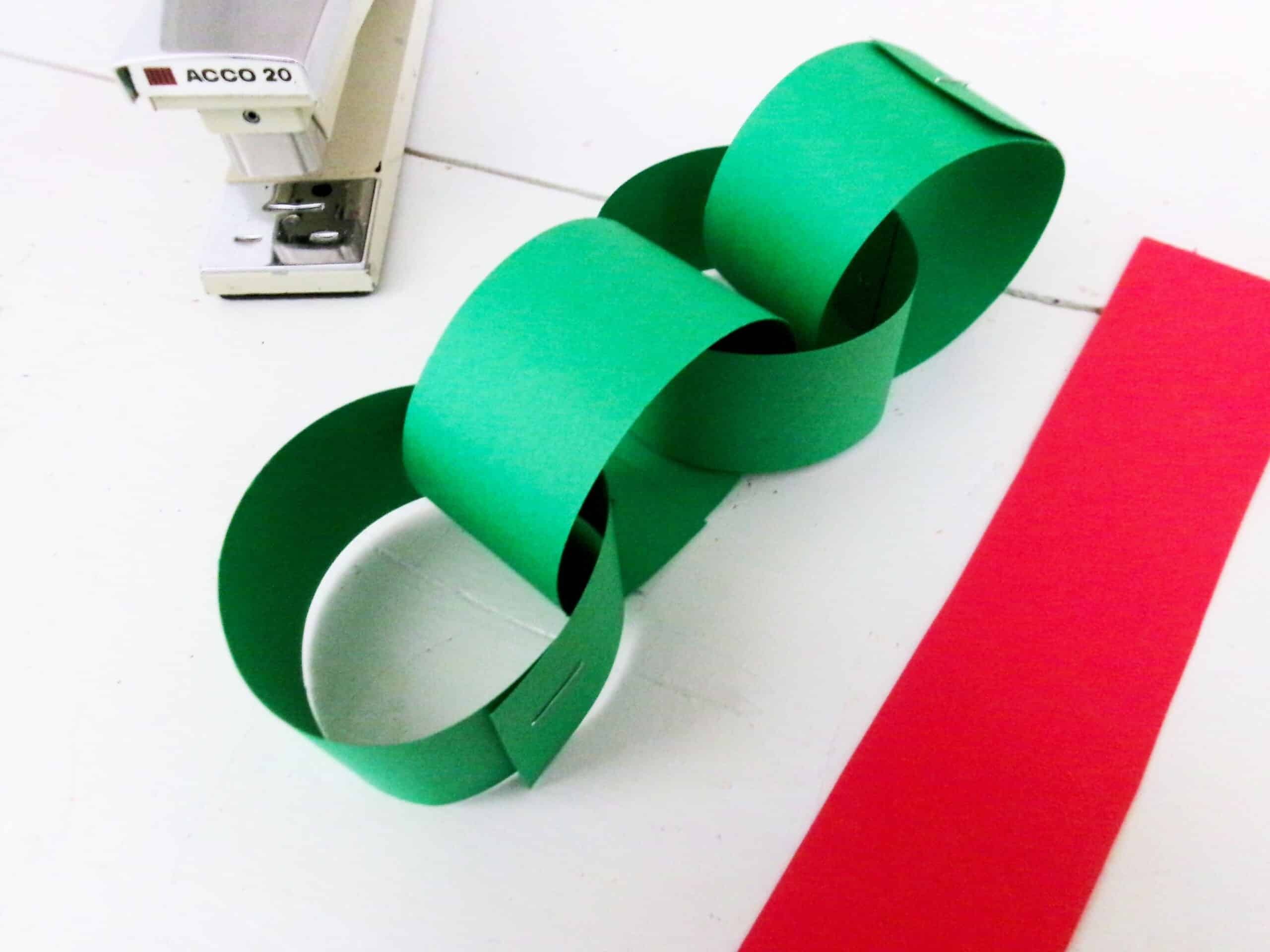 Bring another strip through the first loop and staple together making a chain.