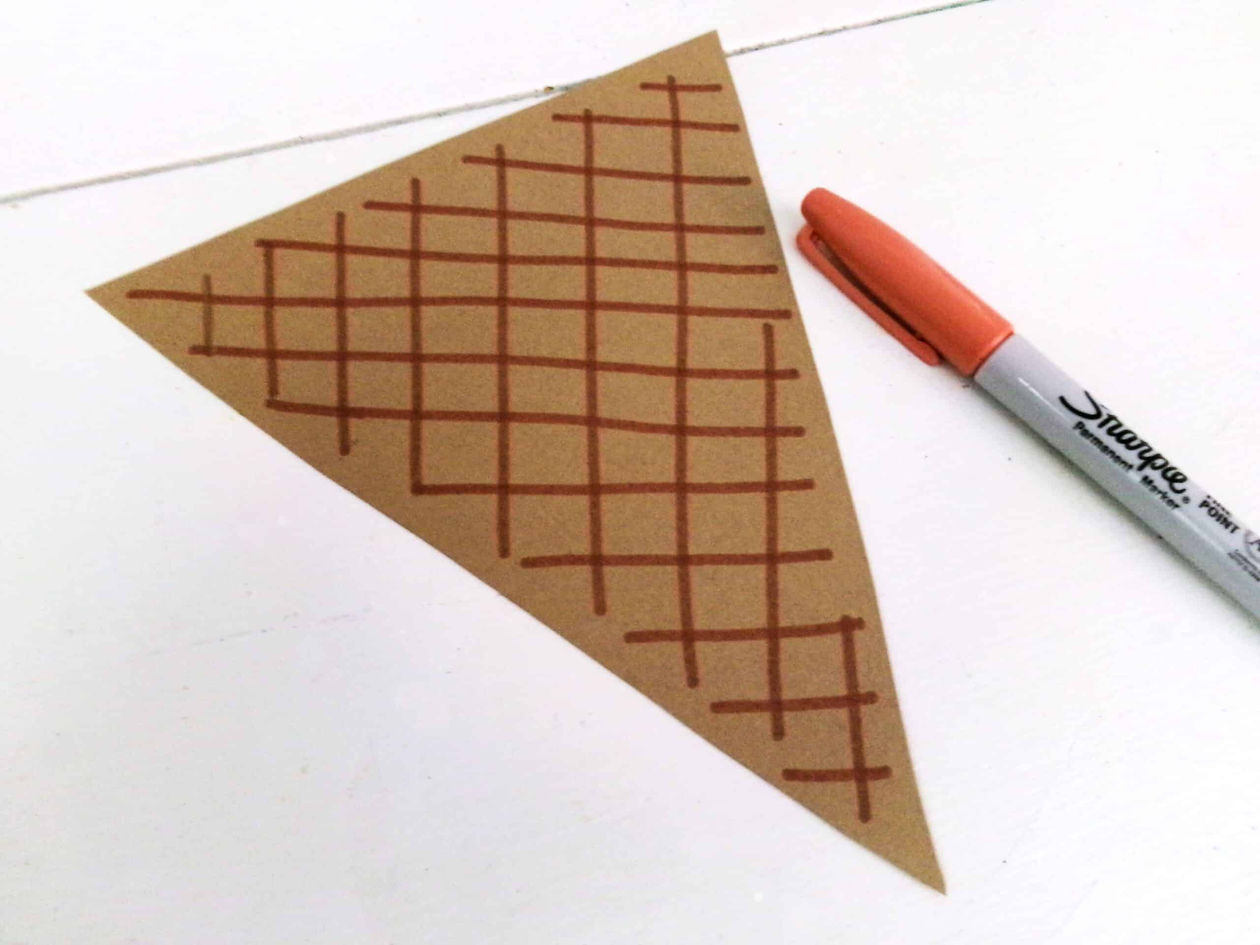 Using a orange or brown marker, draw waffle details along the cone.