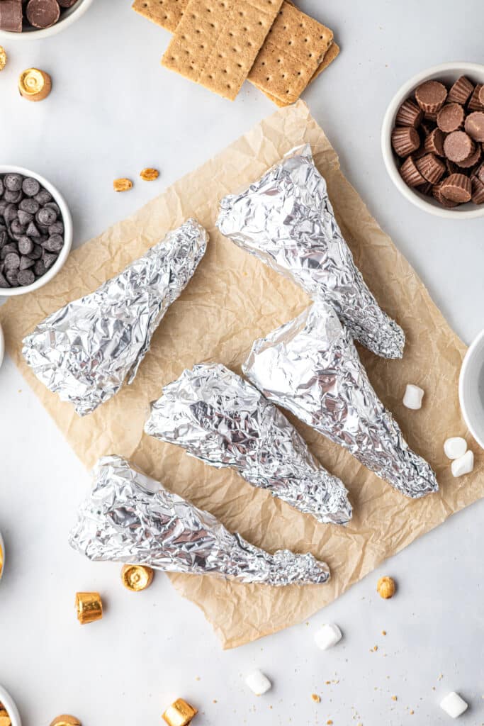 Tightly wrapping the Campfire Cones in tin foil before grilling
