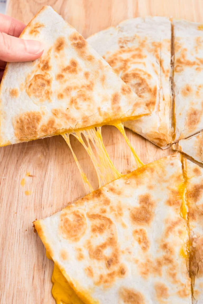 Pulling a cut piece of Cheese Quesadilla with hands