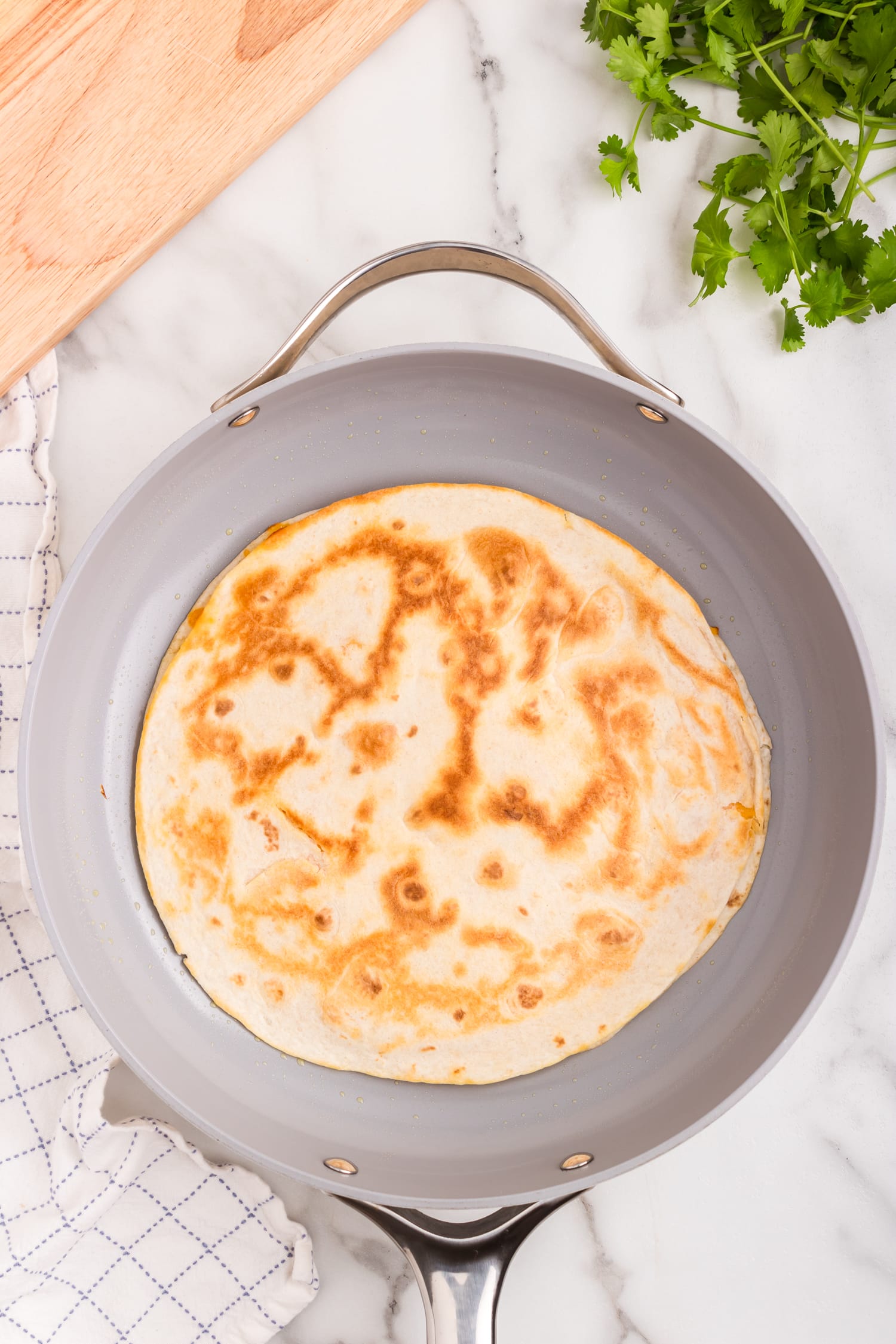 Cheese Quesadilla flipped in the skillet to reveal the golden brown