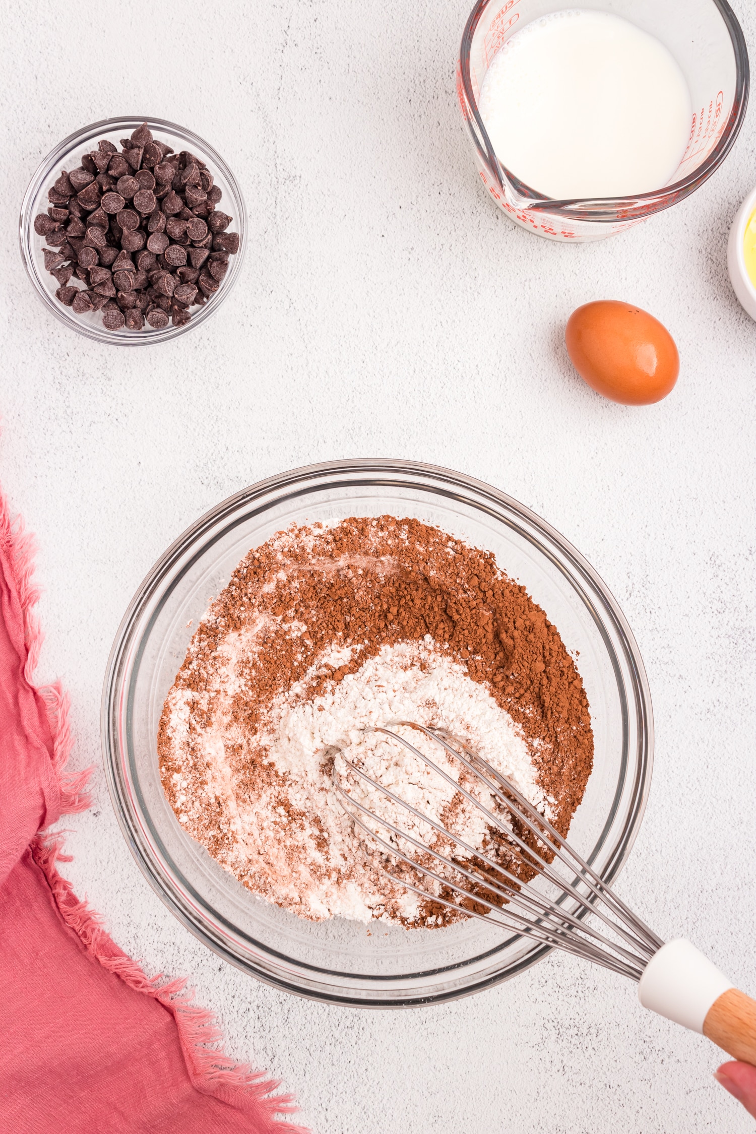 Whisking dry ingredients for Chocolate Pancakes in clear mixing bowl