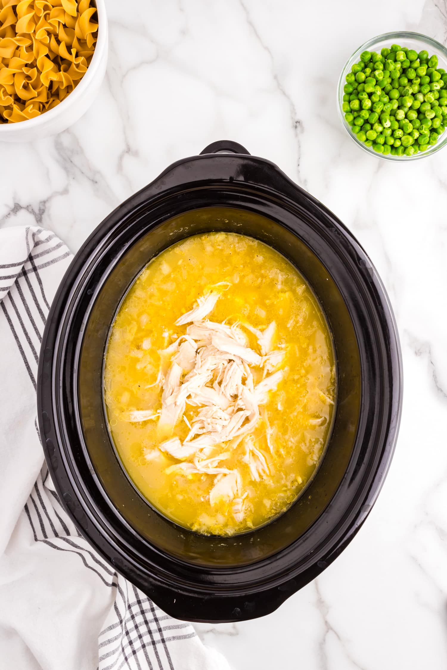 Shredding chicken in crock pot mixture for Crock Pot Chicken and Noodles recipe