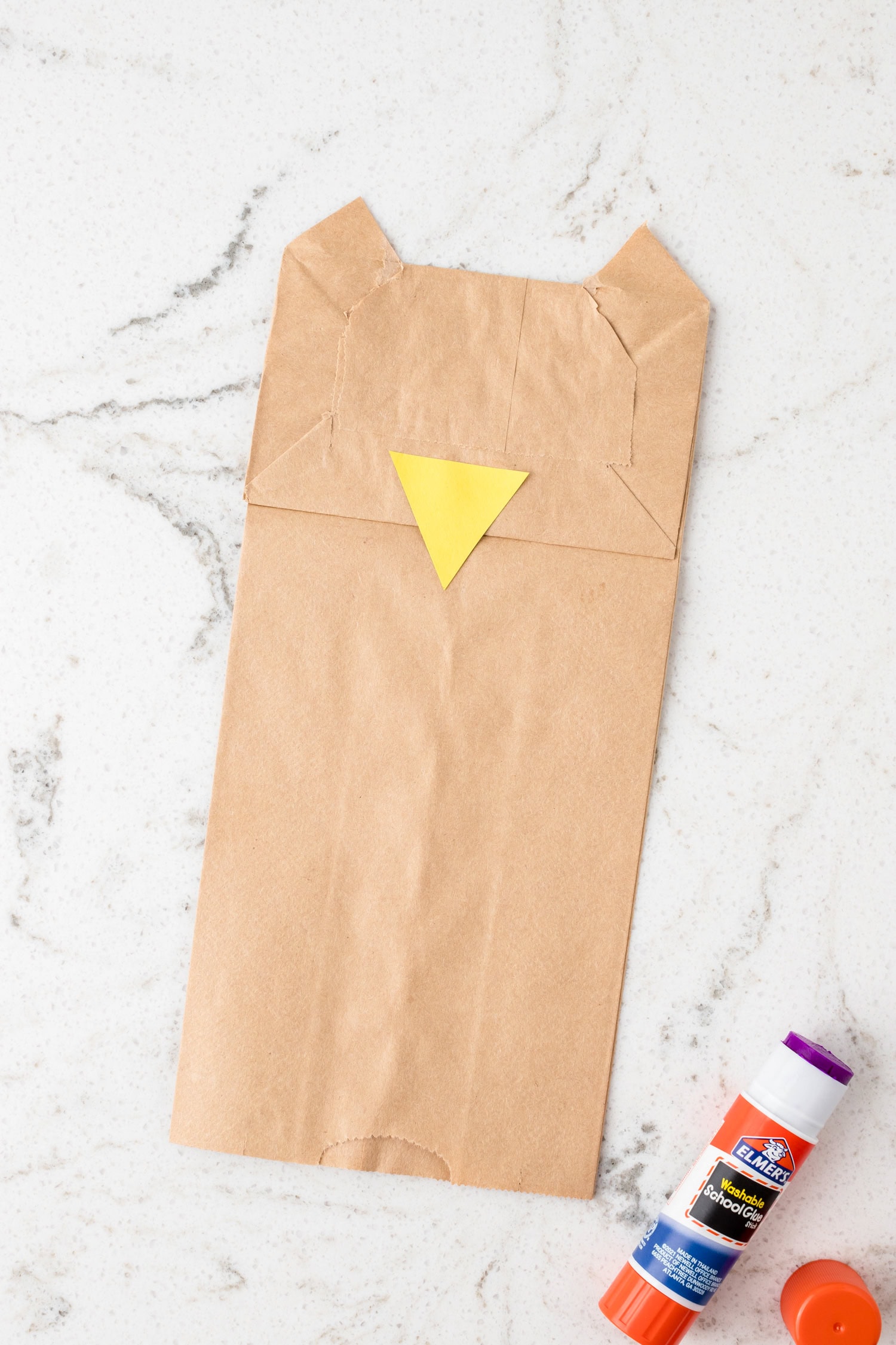 Adding a yellow triangle for the owl's beak for the Paper Bag Owl Craft