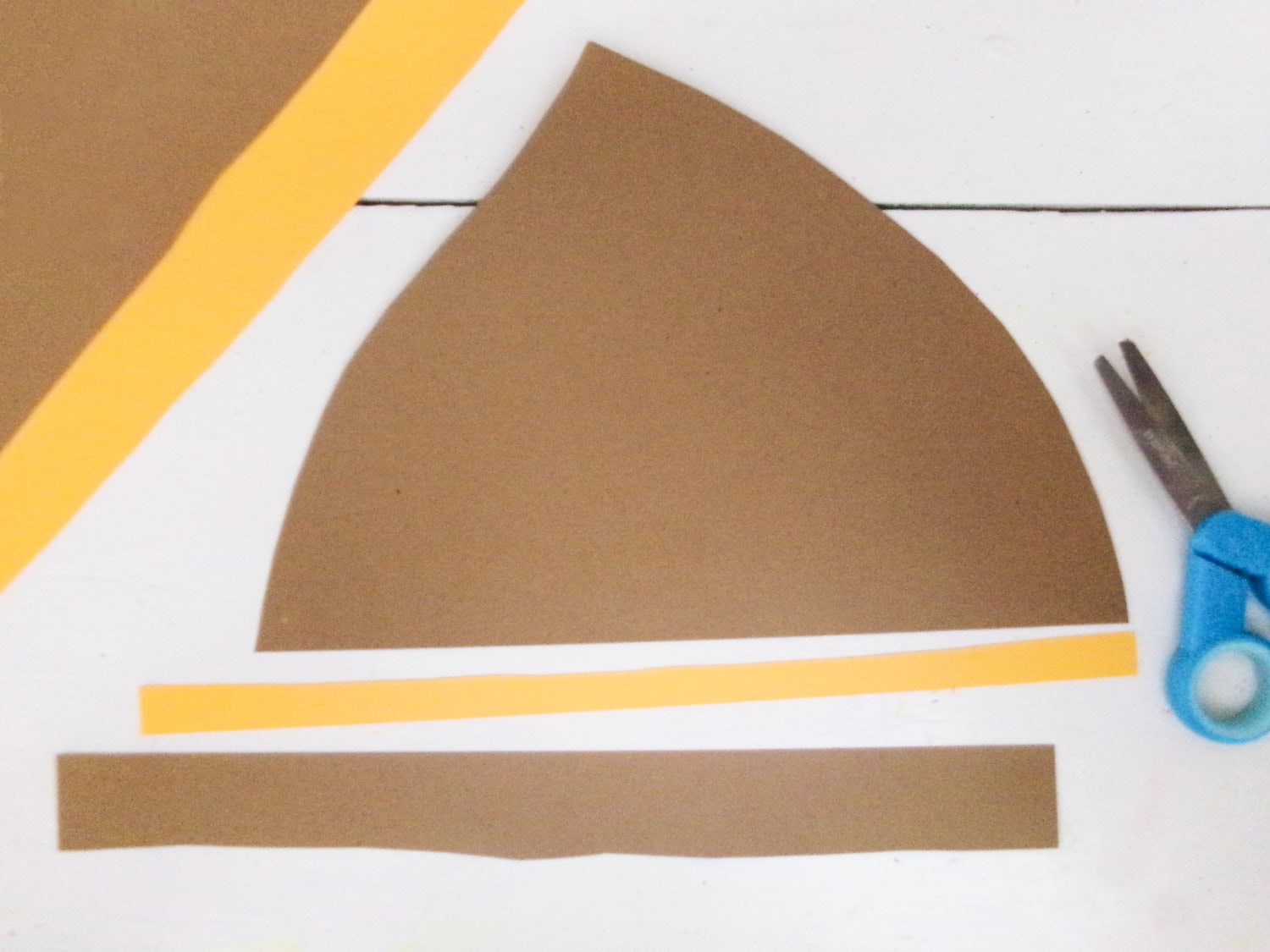 Using the template to cut the parts of the hat for the Paper Plate Scarecrow Craft