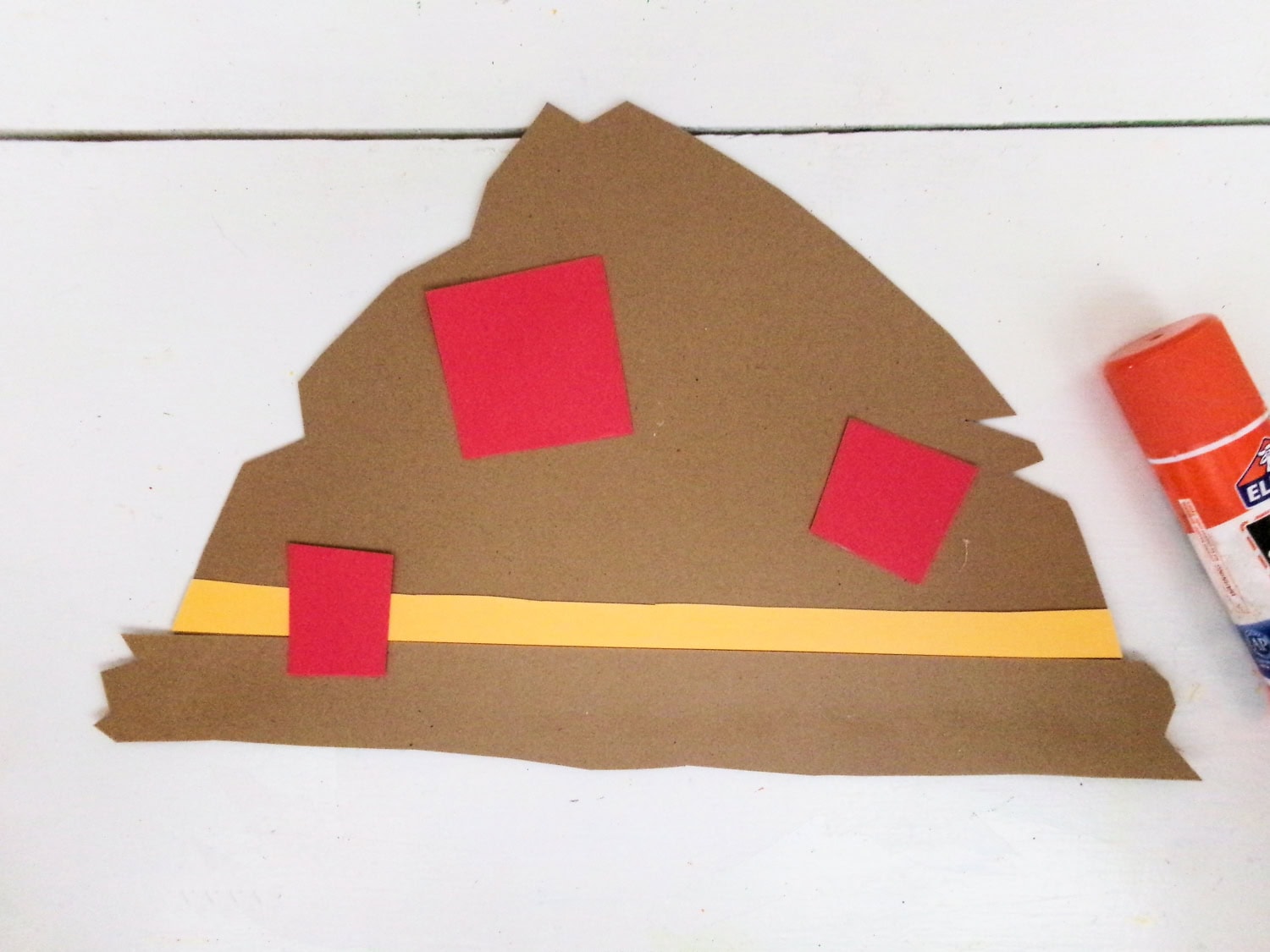 Adding red construction paper to hat to give it a patched look with glue for the Paper Plate Scarecrow Craft