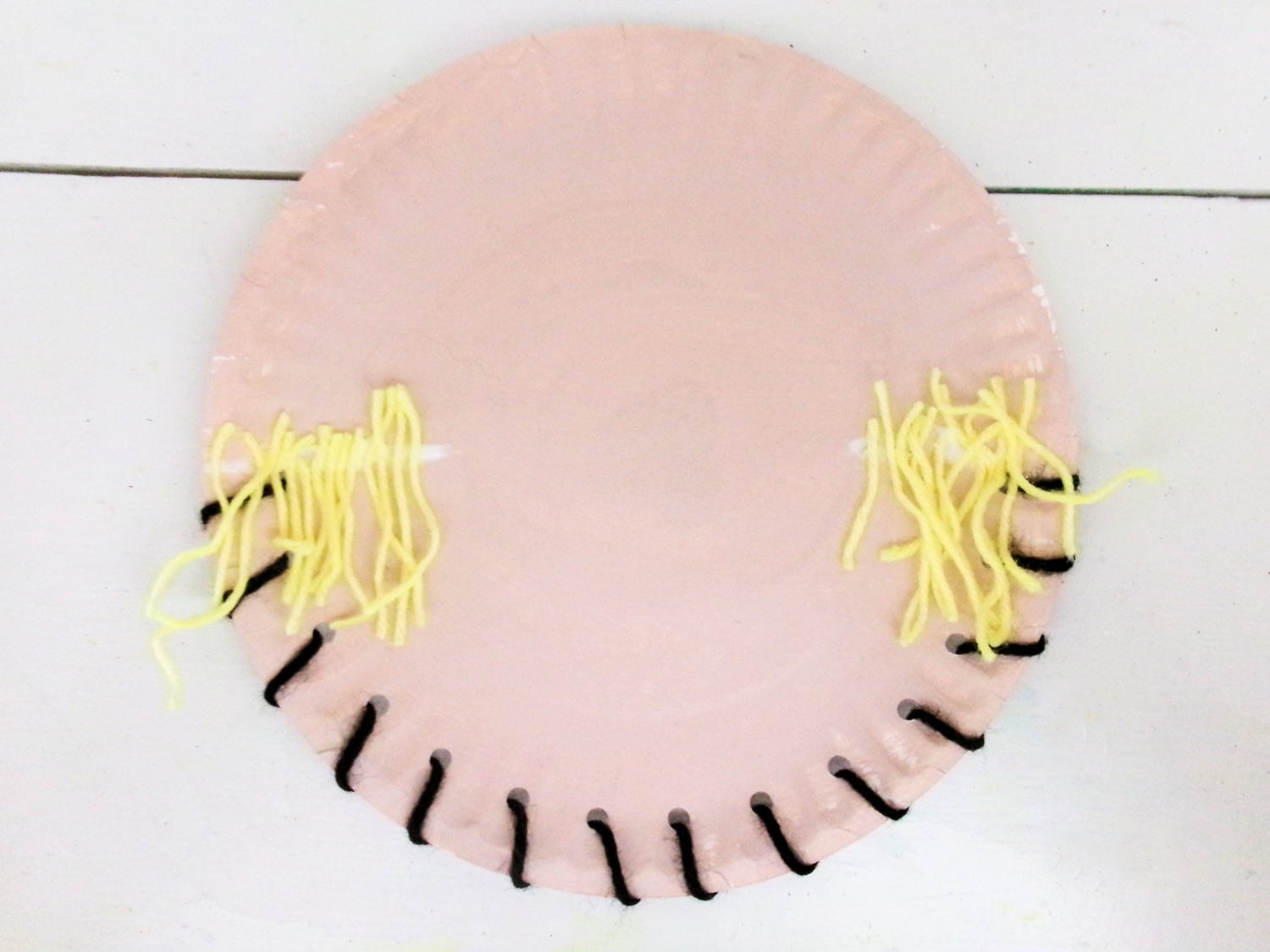 Yellow yarn glued to face to mimmick straw on teh Paper Plate Scarecrow Craft