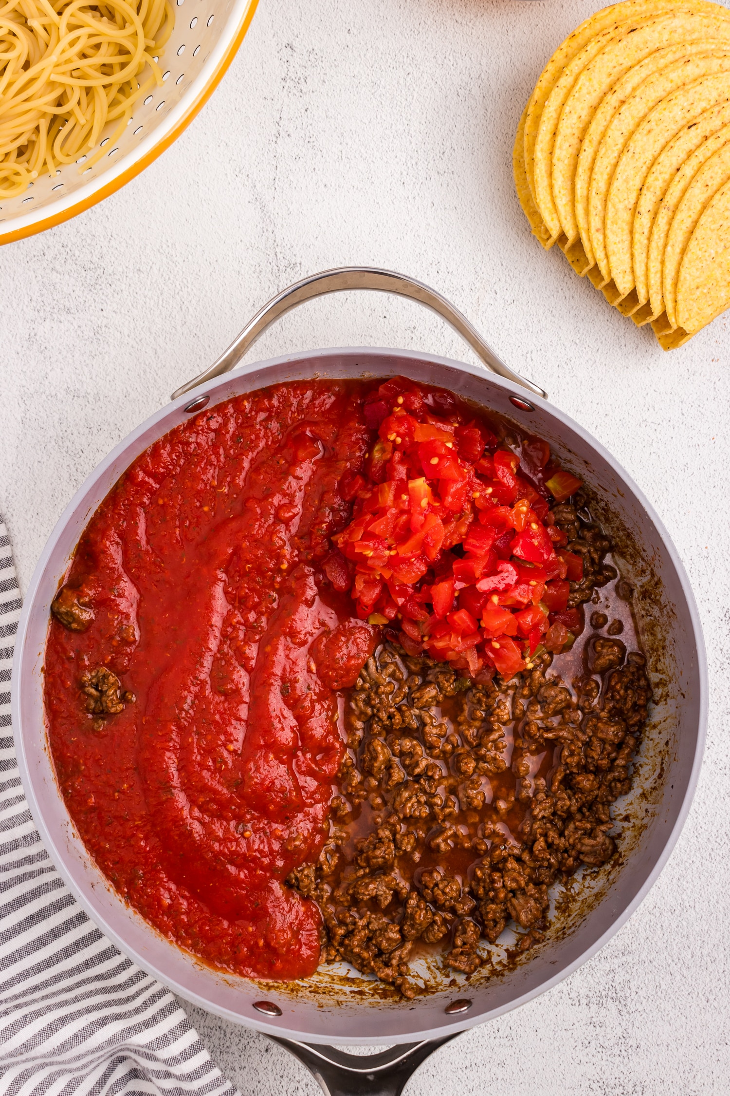 Adding tomato/green chille mixture and spaghetti sauce to taco mixture for Spaghetti Tacos