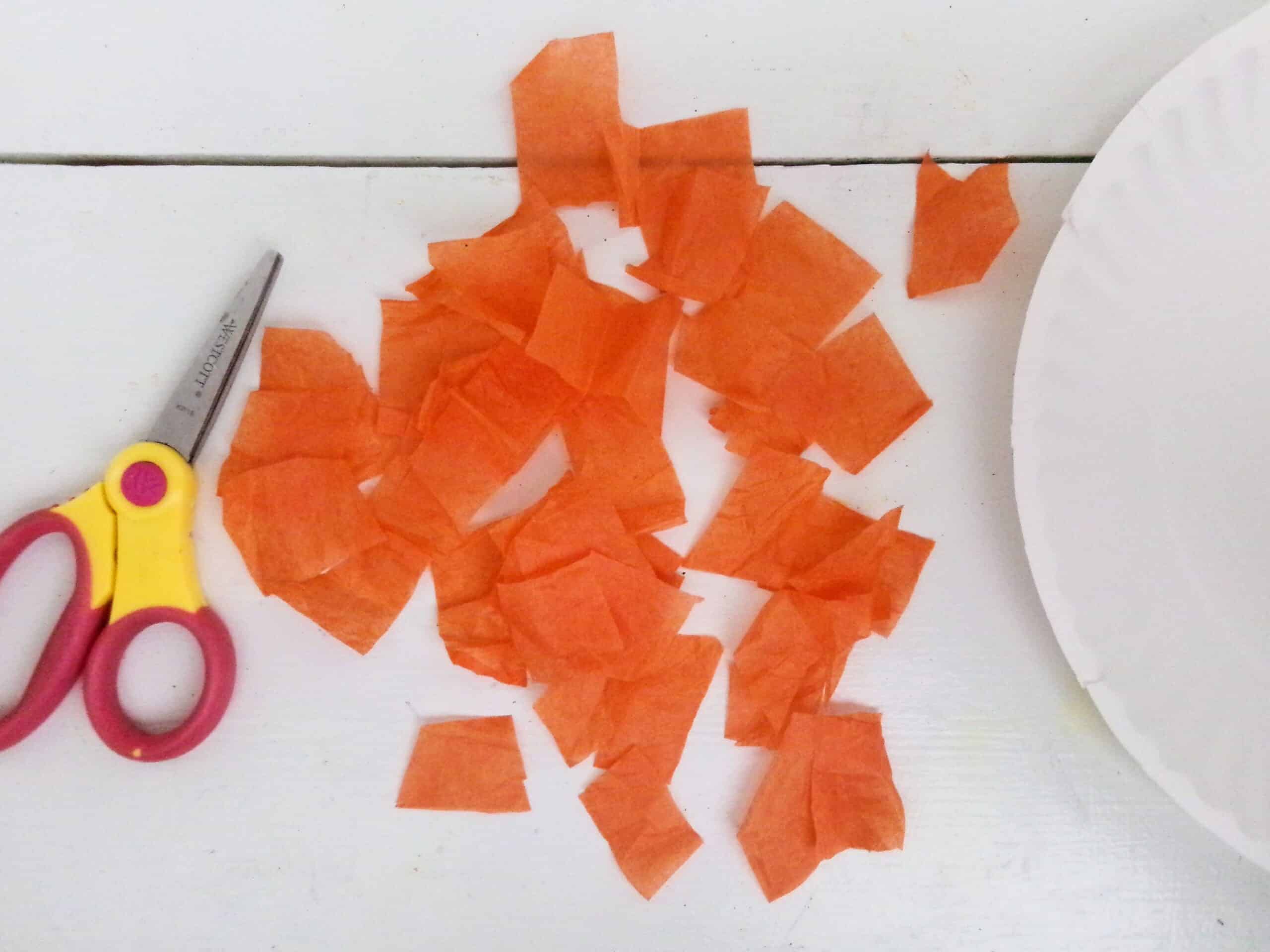 Begin by cutting a bunch of small squares of orange tissue paper.
